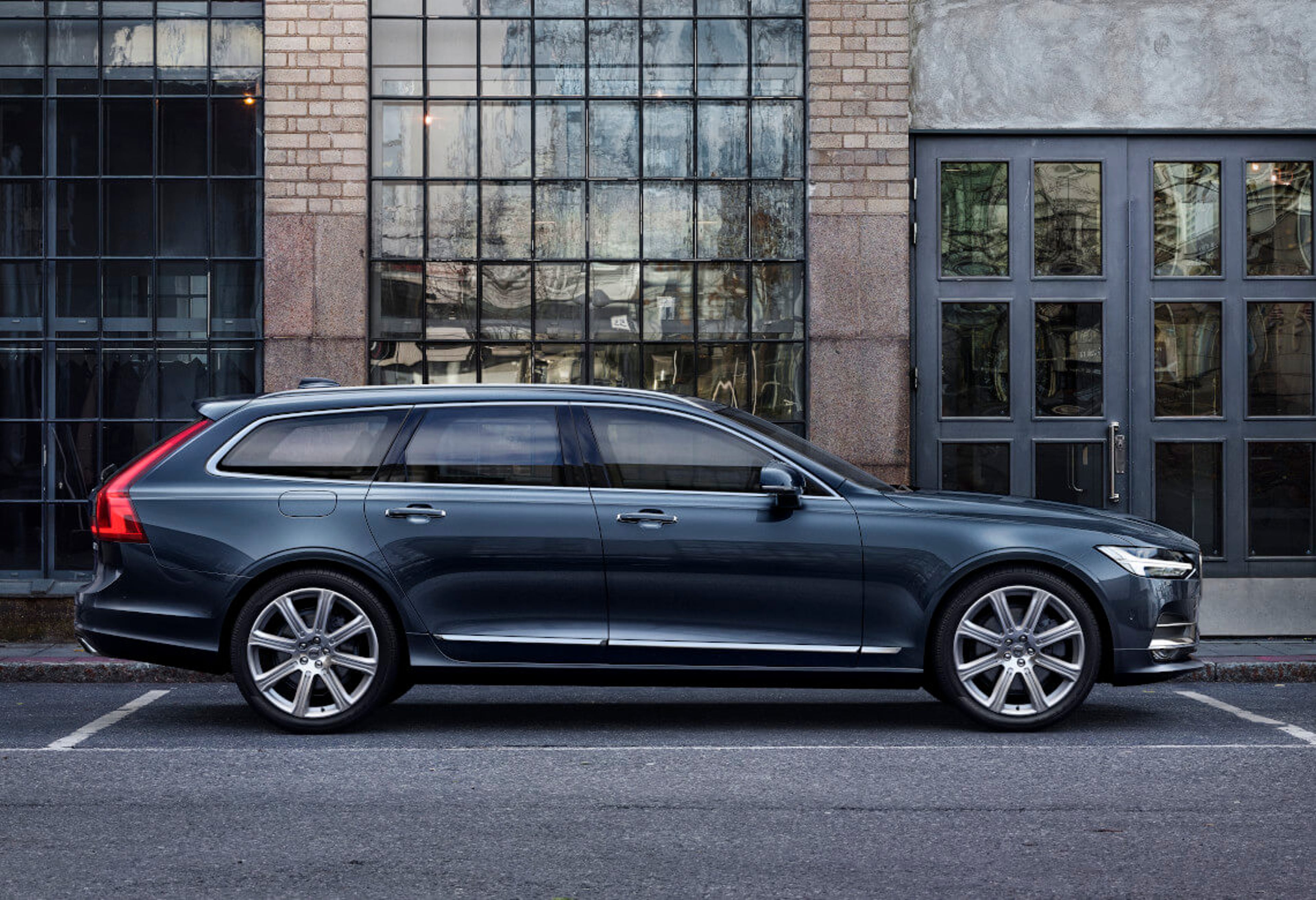 Volvo V90 steht vor einer Fensterfront