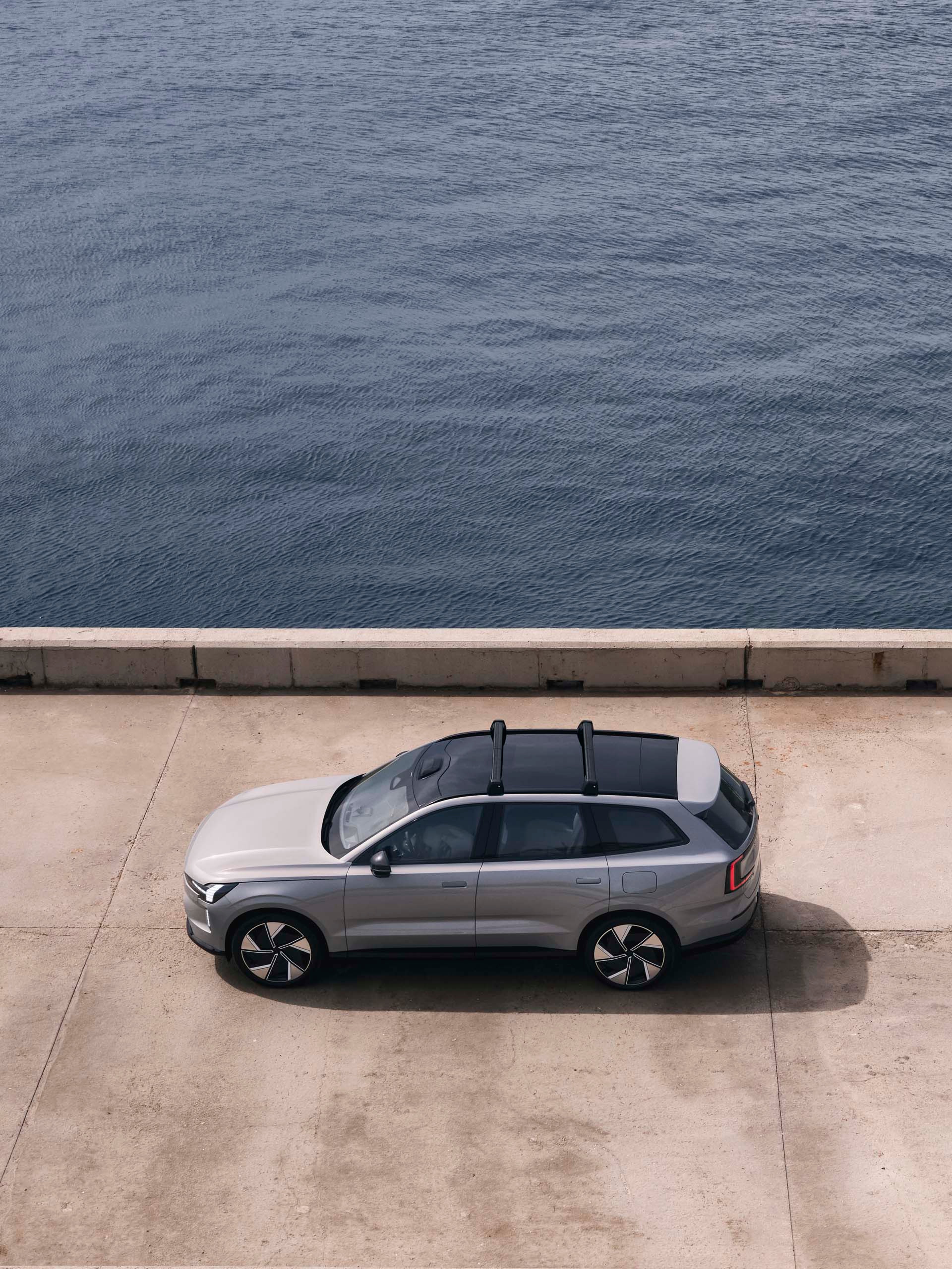 Un Volvo EX90 cruzando un puente junto al mar