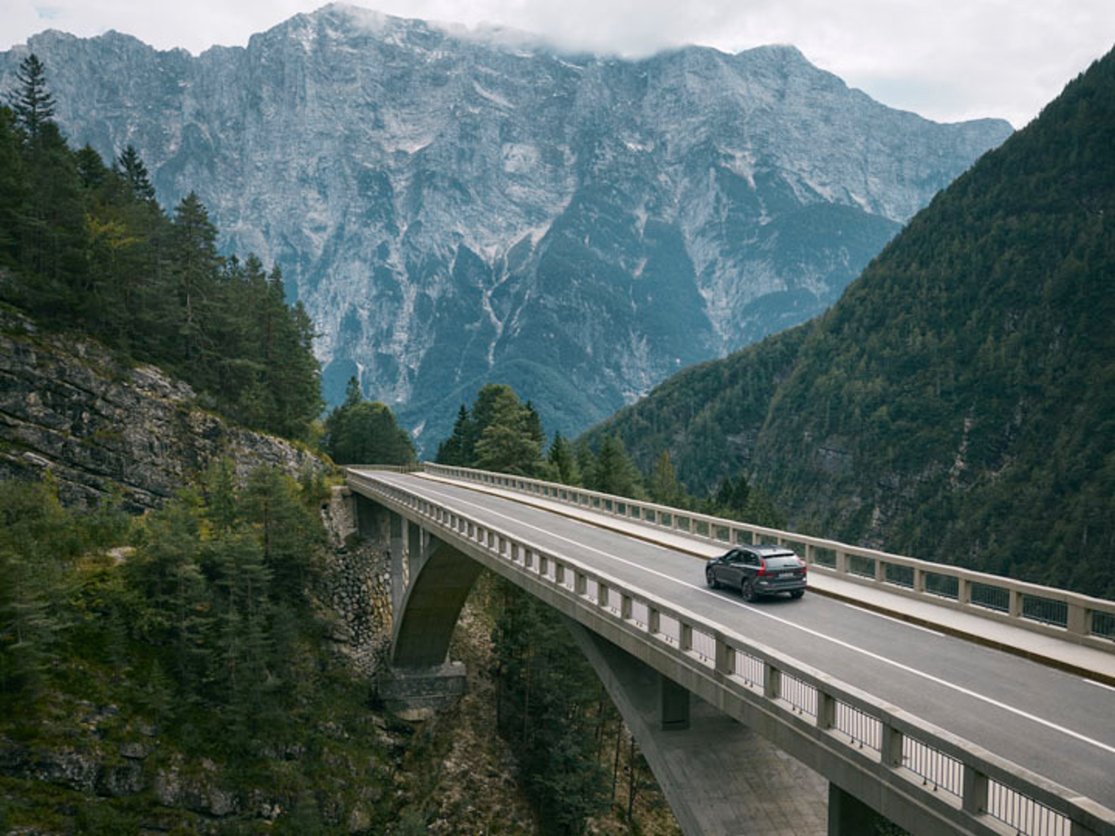 Volvo XC60 entre montañas cruzando un puente