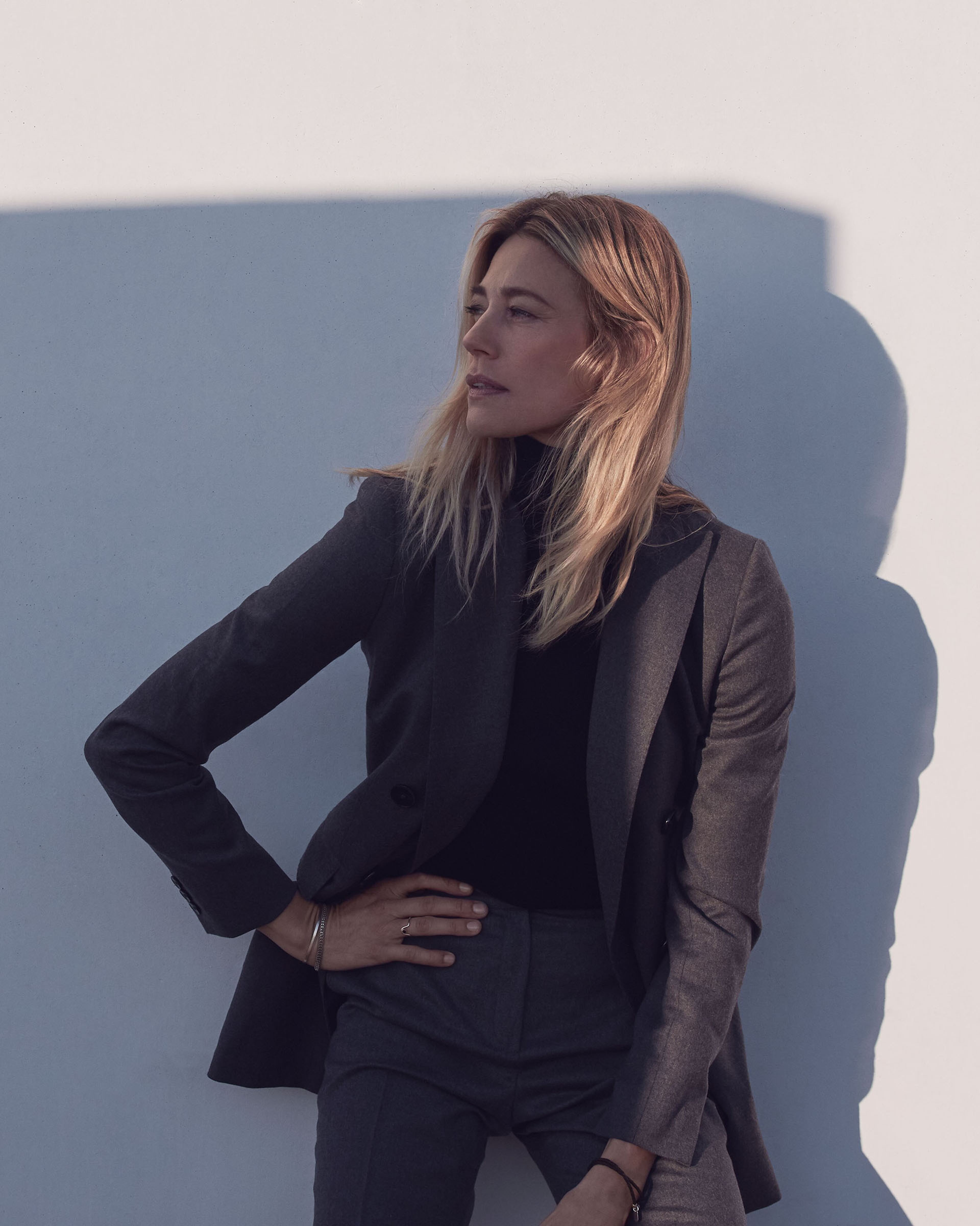 Blonde vrouw tegen witte muur