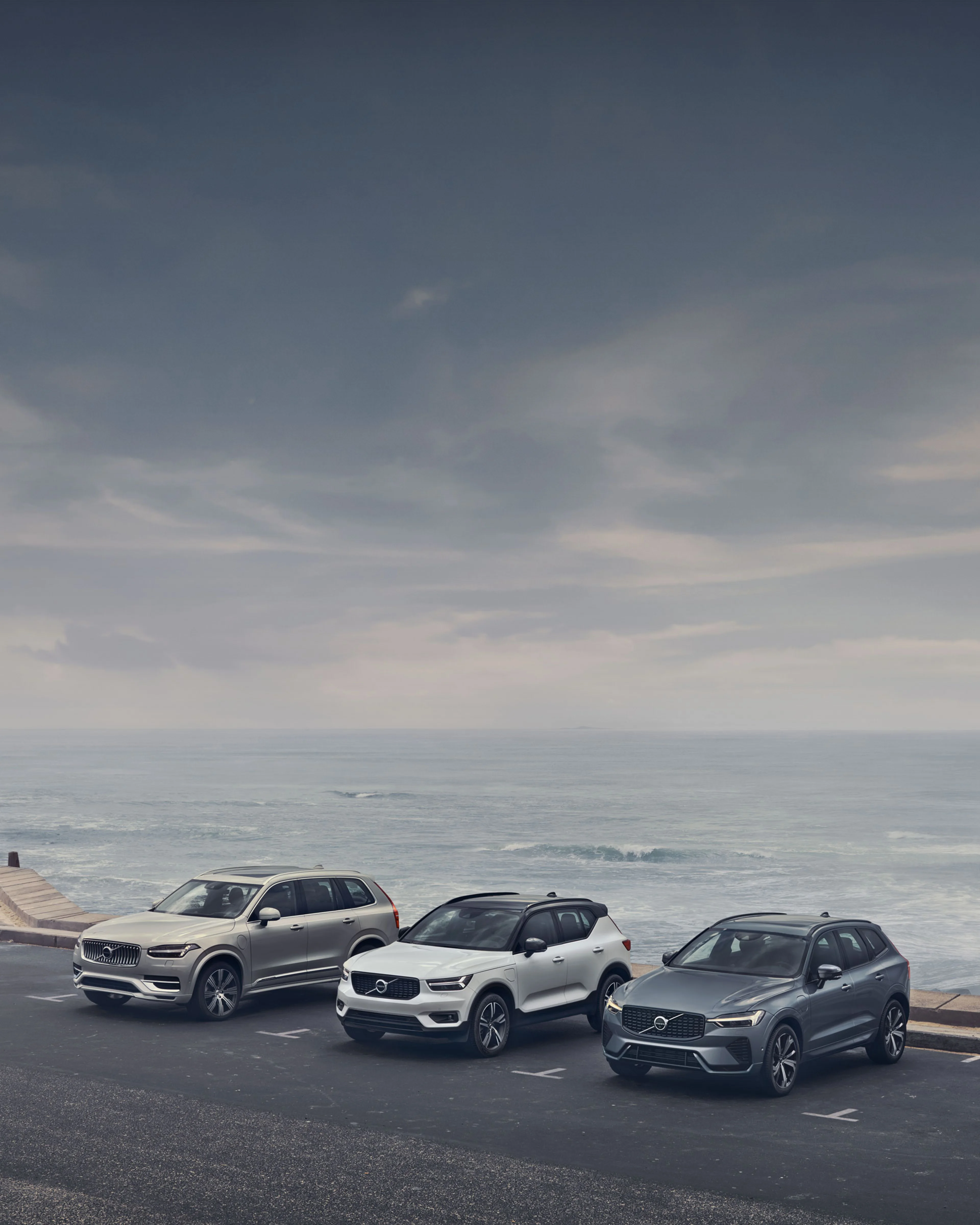 Familia de vehículos Volvo estacionados a la orilla del mar