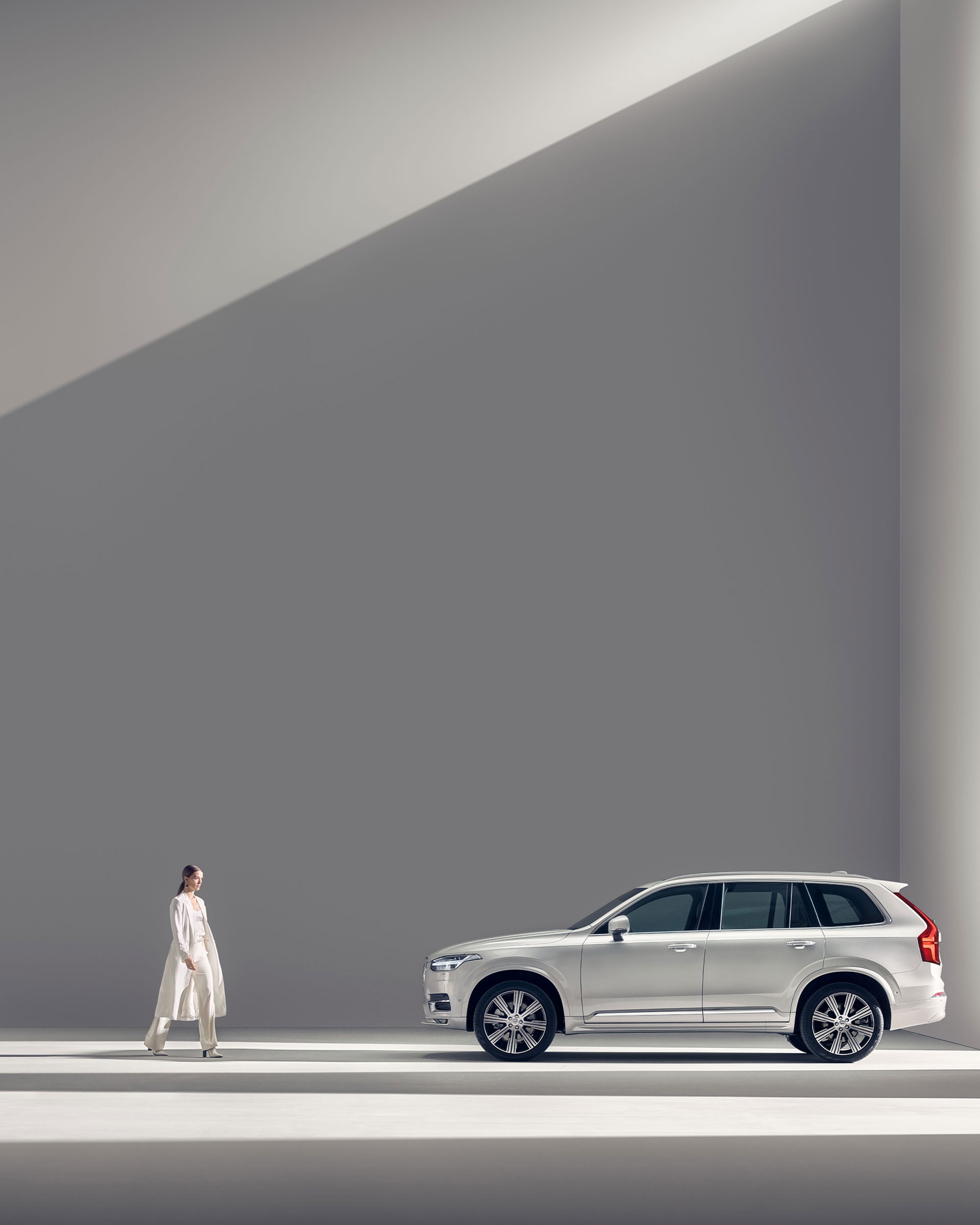 Kvinna vid vit Volvo