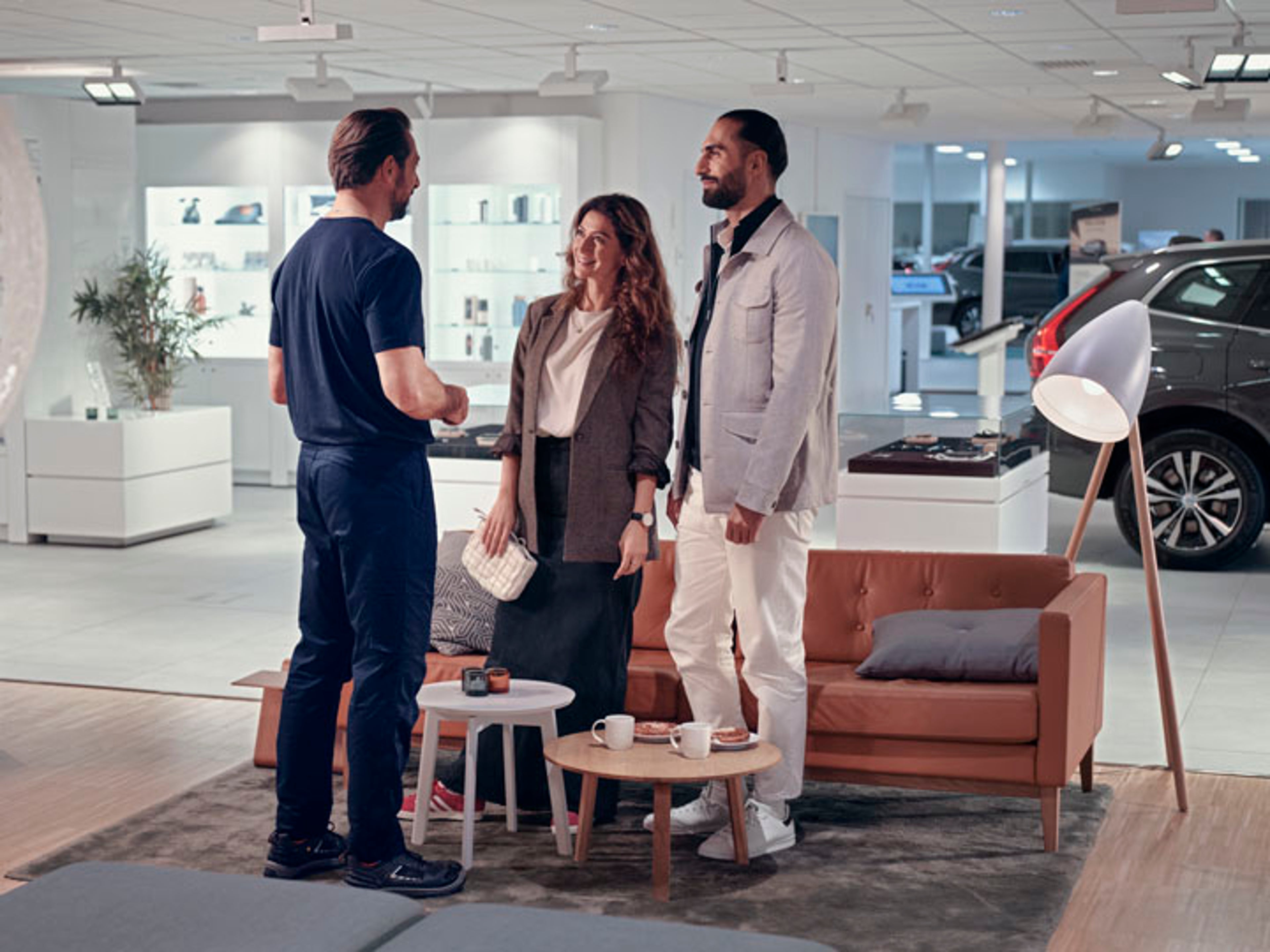 Una pareja conversando con un técnico en un taller o servicio oficial Volvo