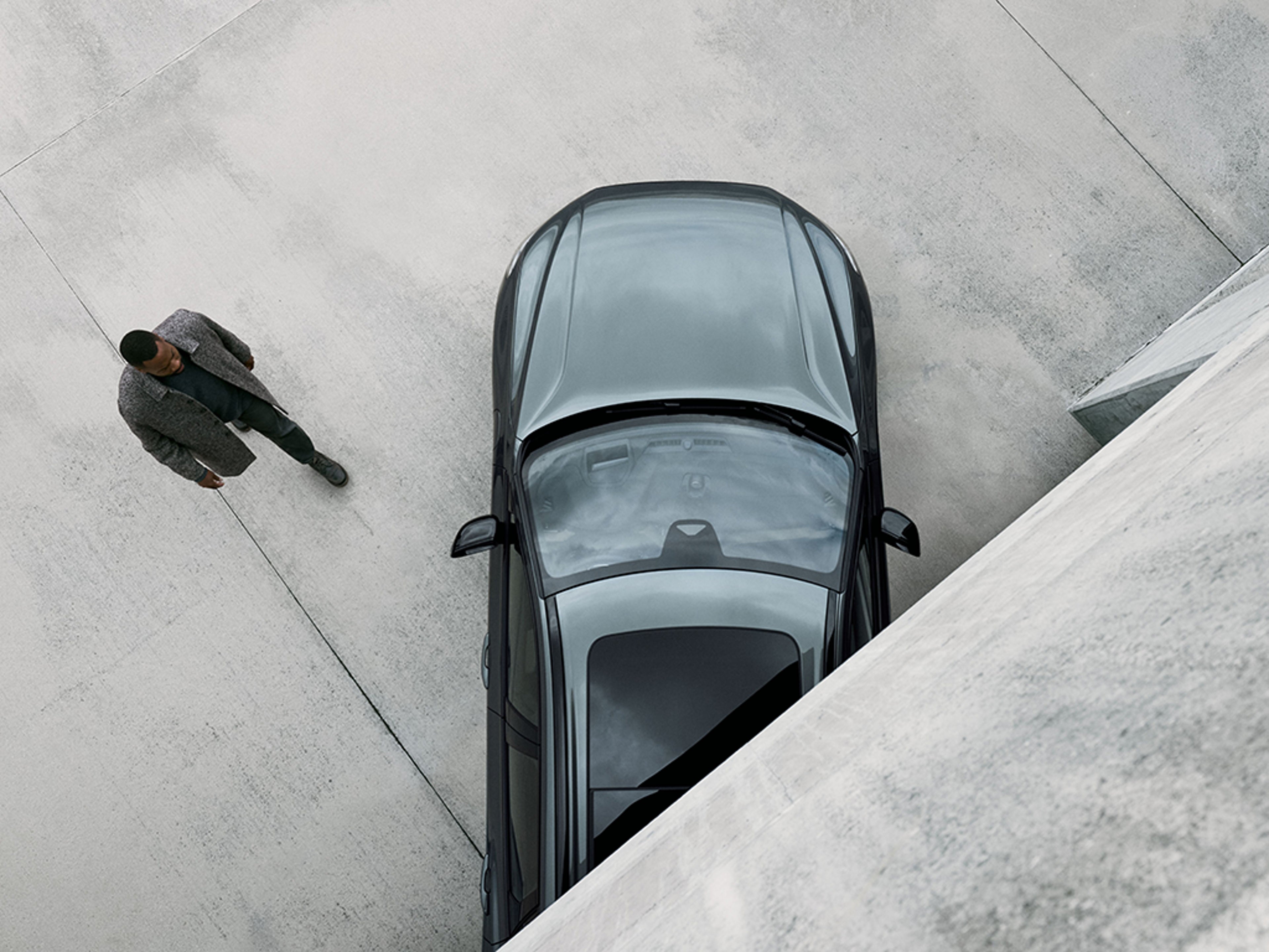 Ein Mann läuft auf einen Volvo XC60 zu.