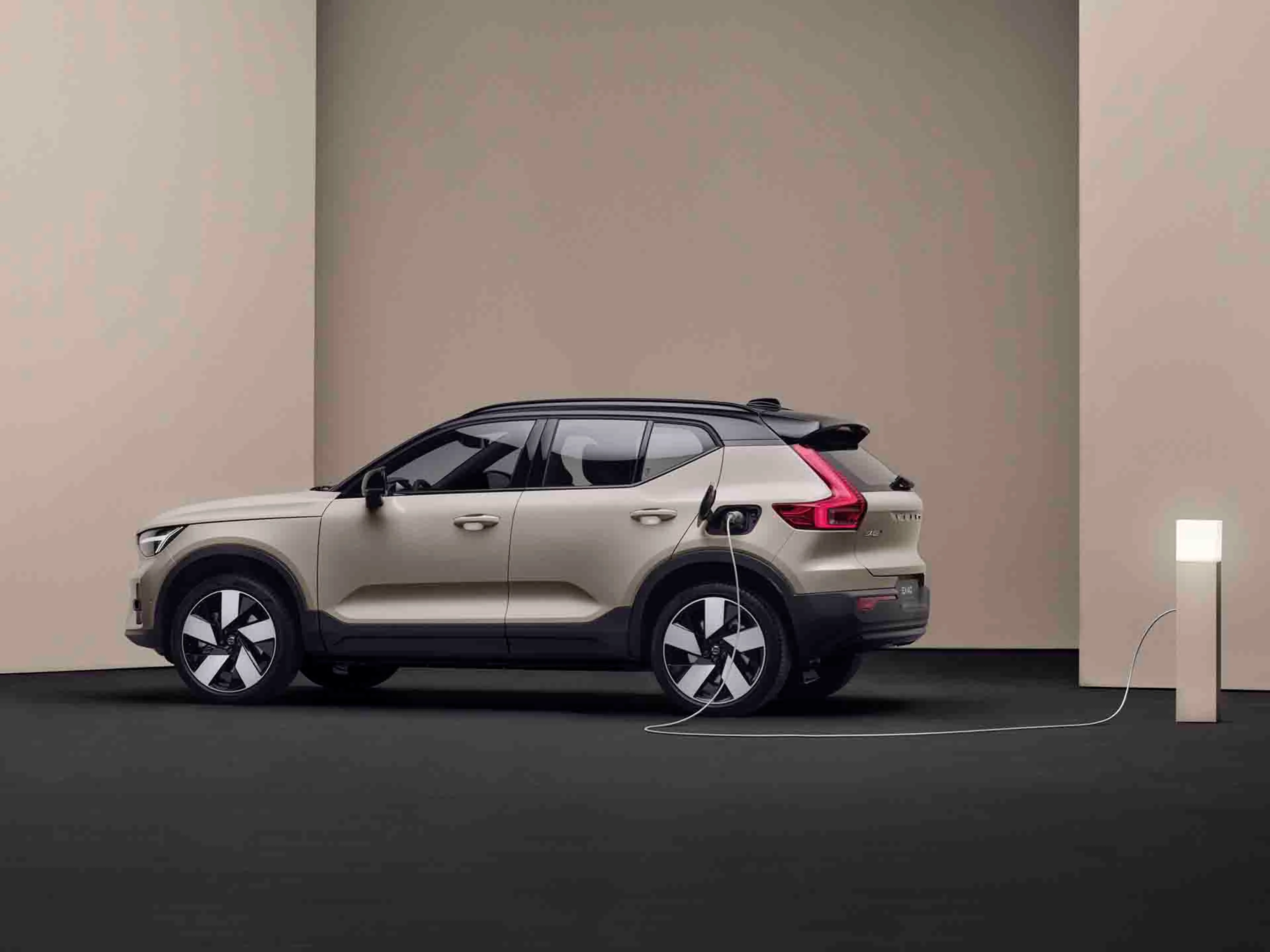 Volvo EX40 eléctrico y un cargador al lado