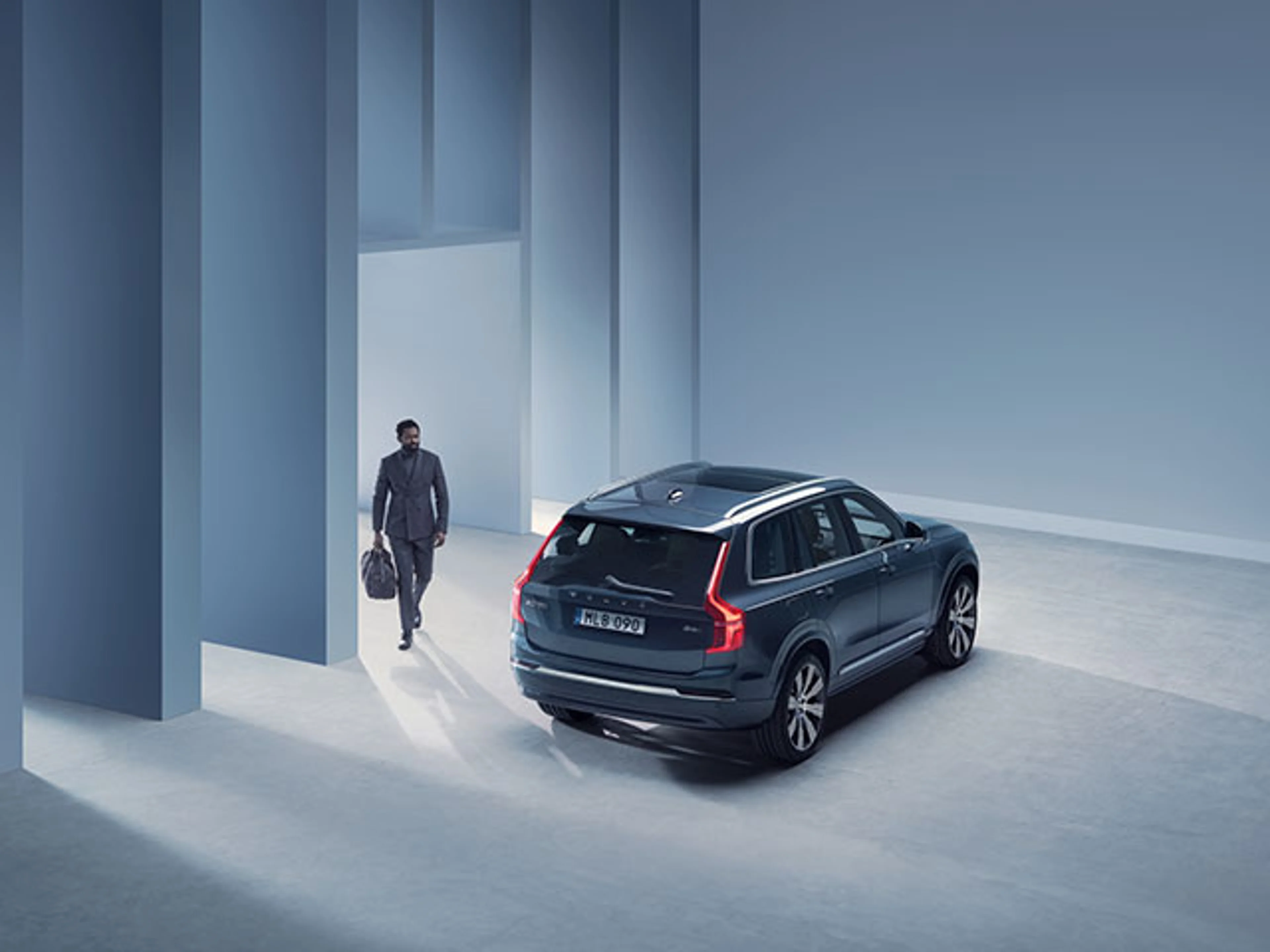 Man går mot Volvo XC90 i blå studio