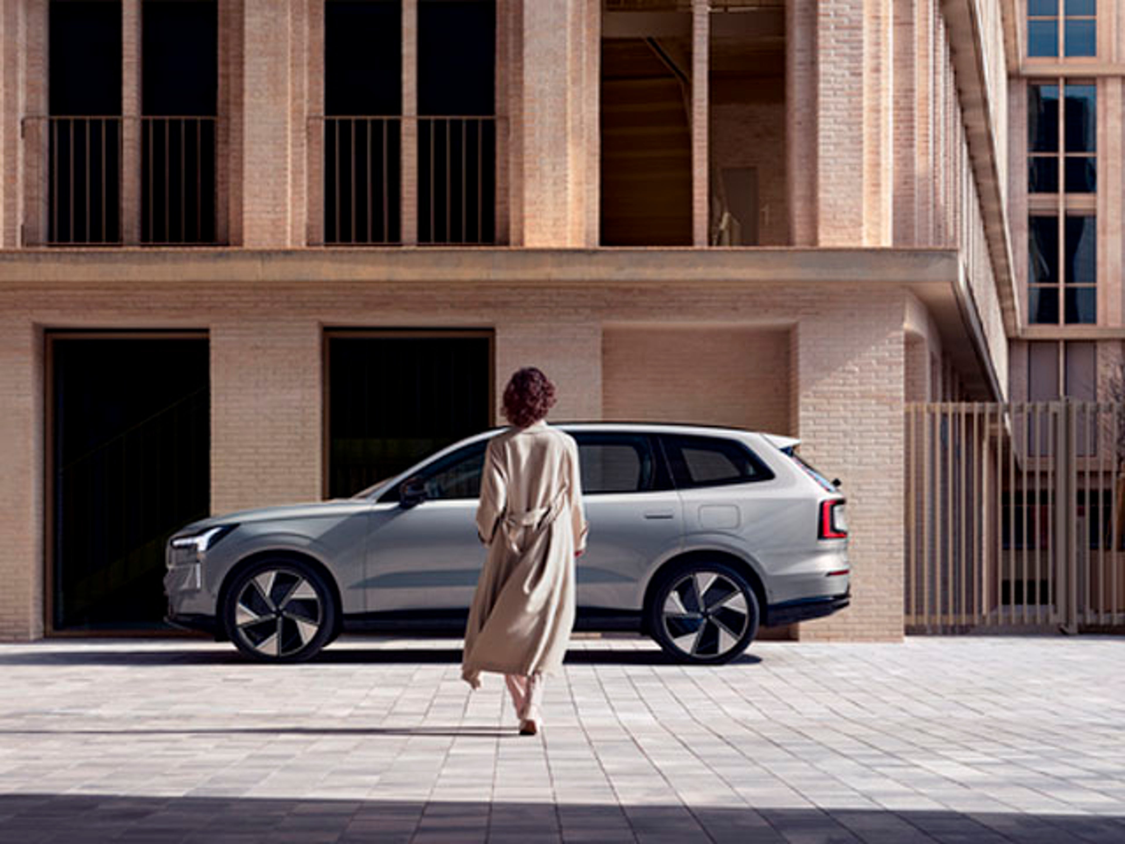 Una mujer caminando hacia un Volvo EX90