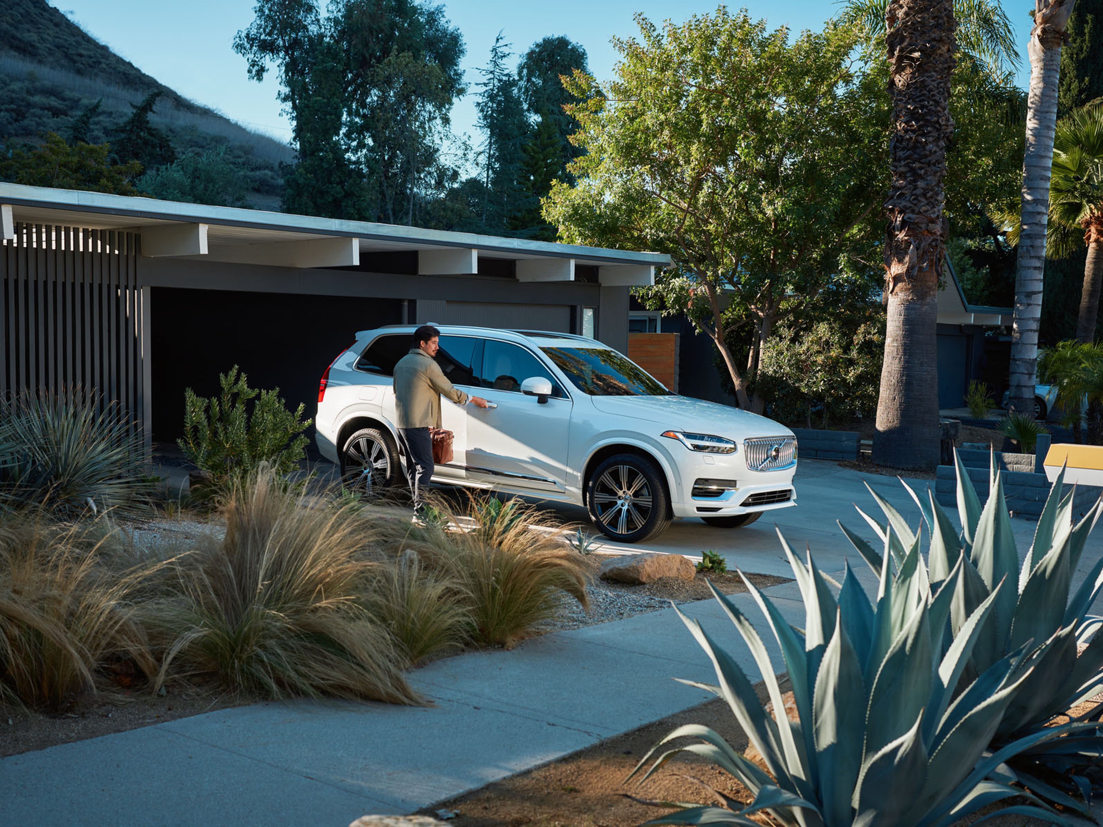 Volvo American Medical Association Offer - man entering XC90 plug-in hybrid in front of house