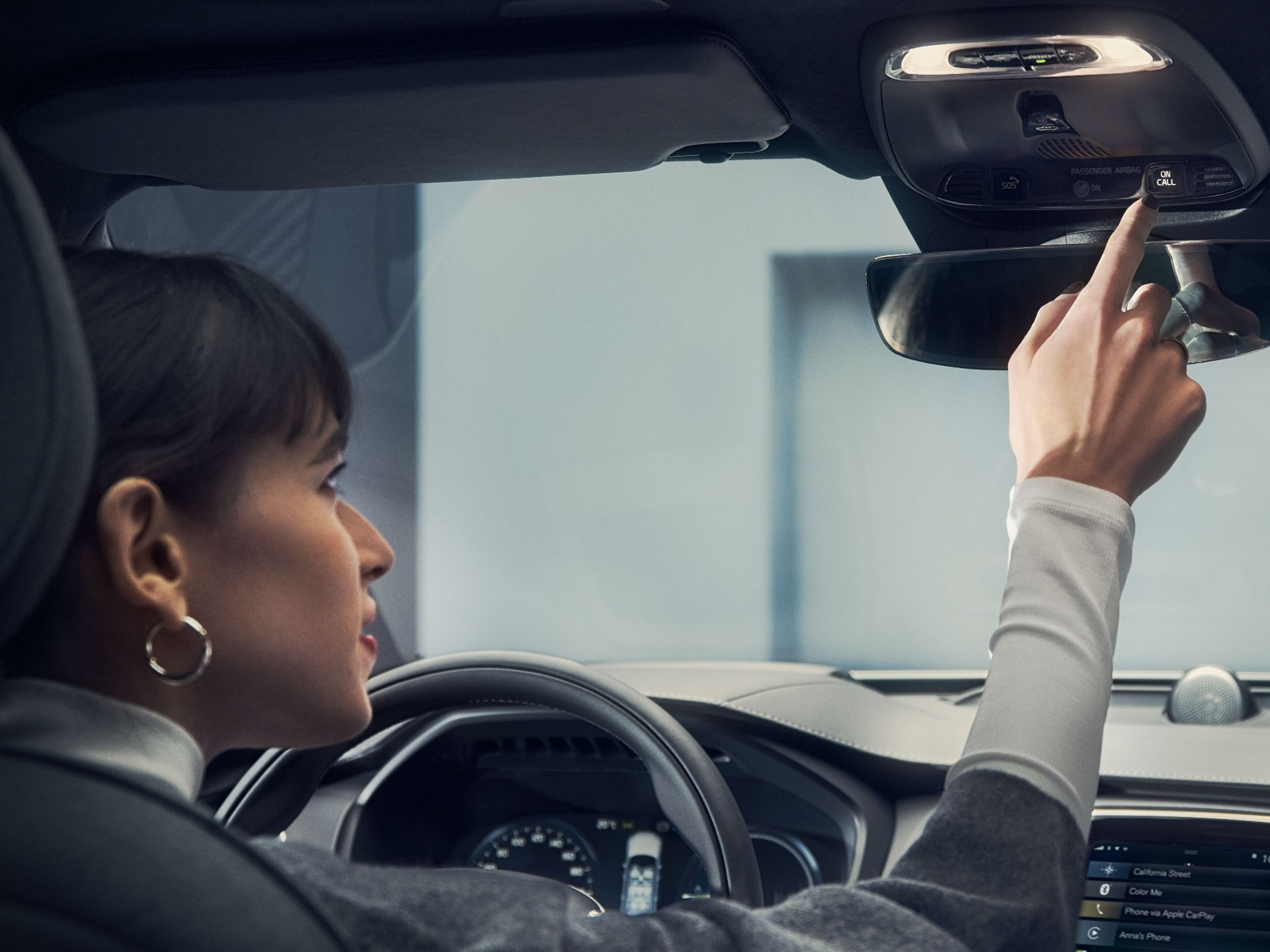 Mulher dentro de um volvo a utilizar o botão "On Call"