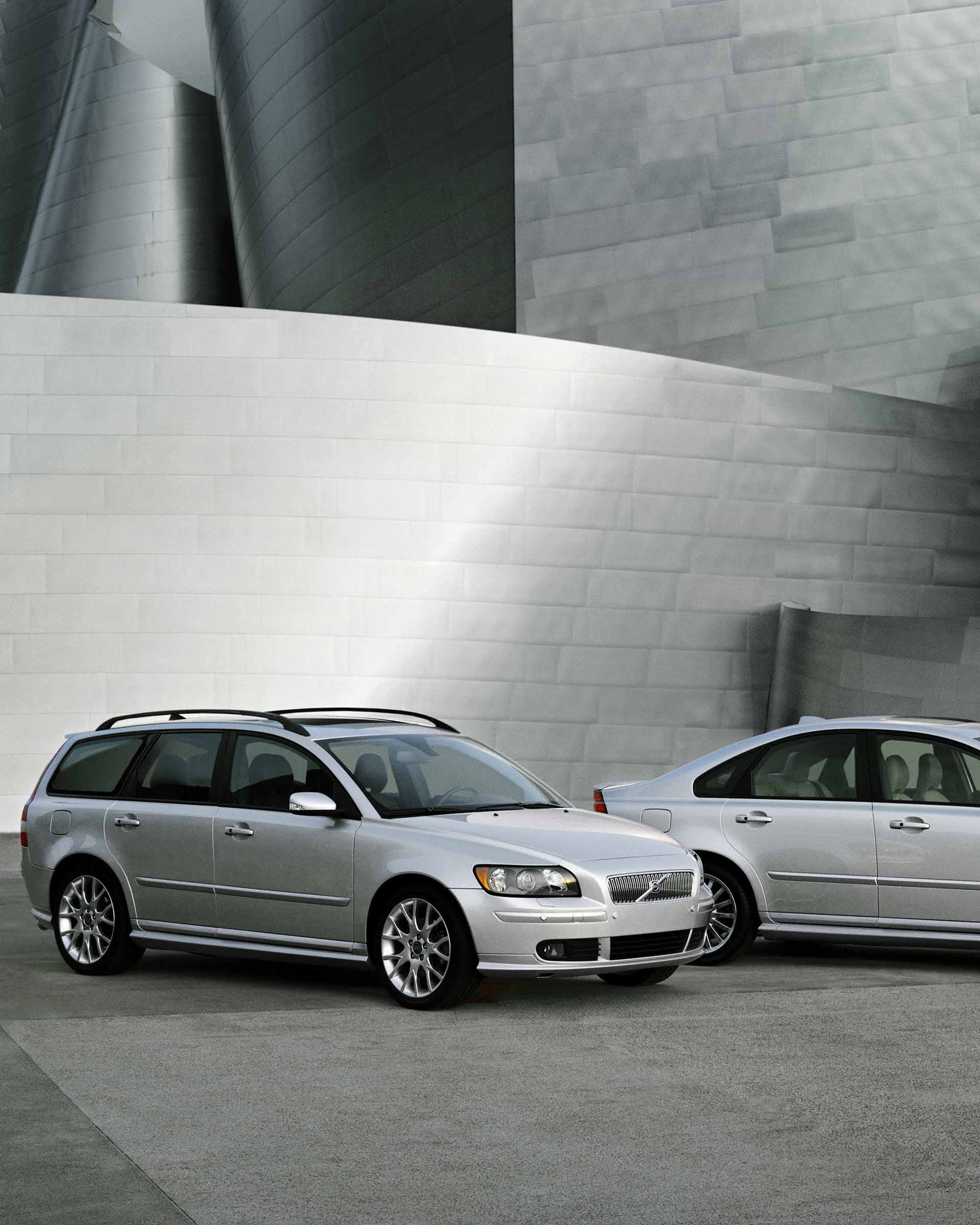 Ein Volvo V50 und ein Volvo S40 stehen vor einer Mauer.