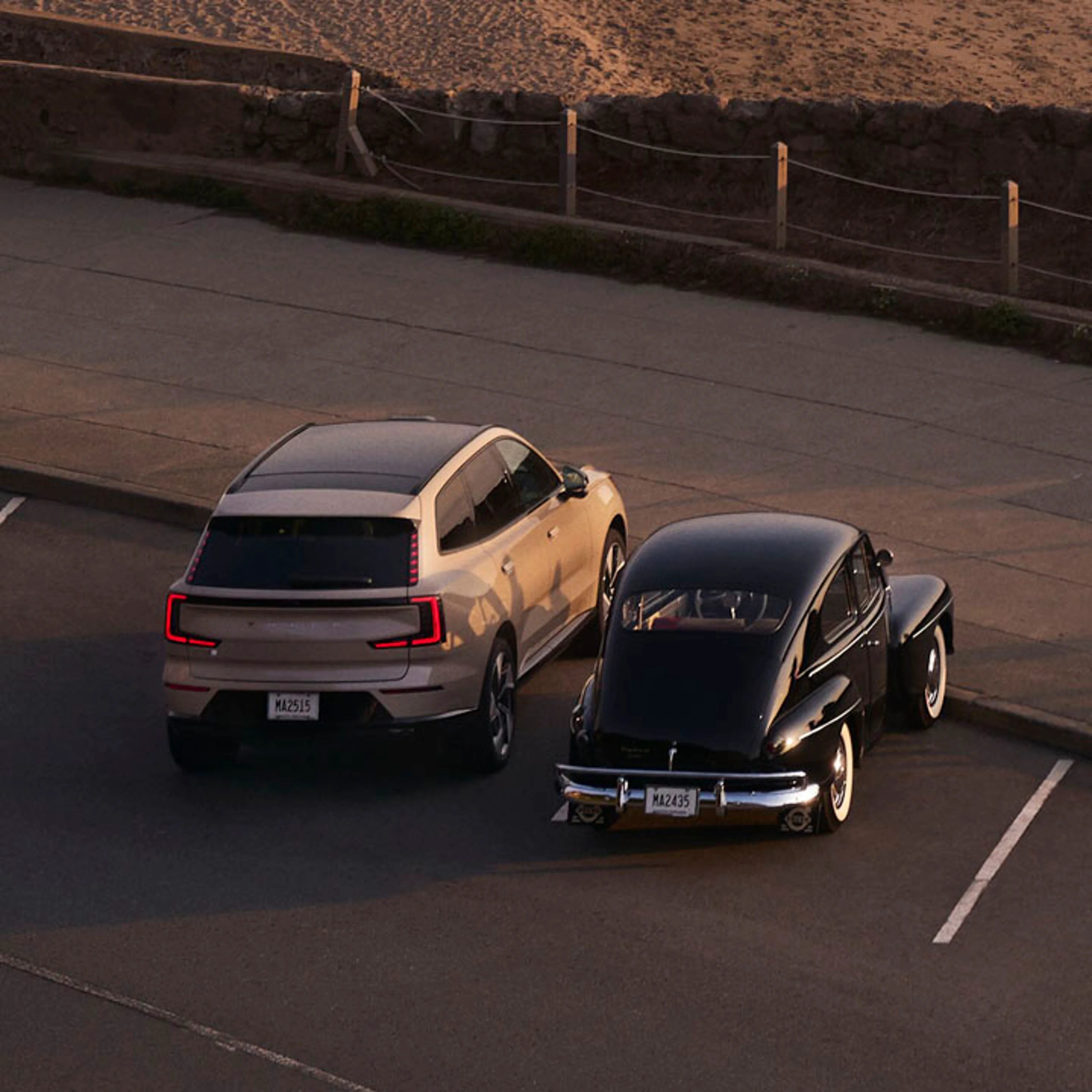 Un Volvo eléctrico junto a un Volvo clásico en una playa junto al mar