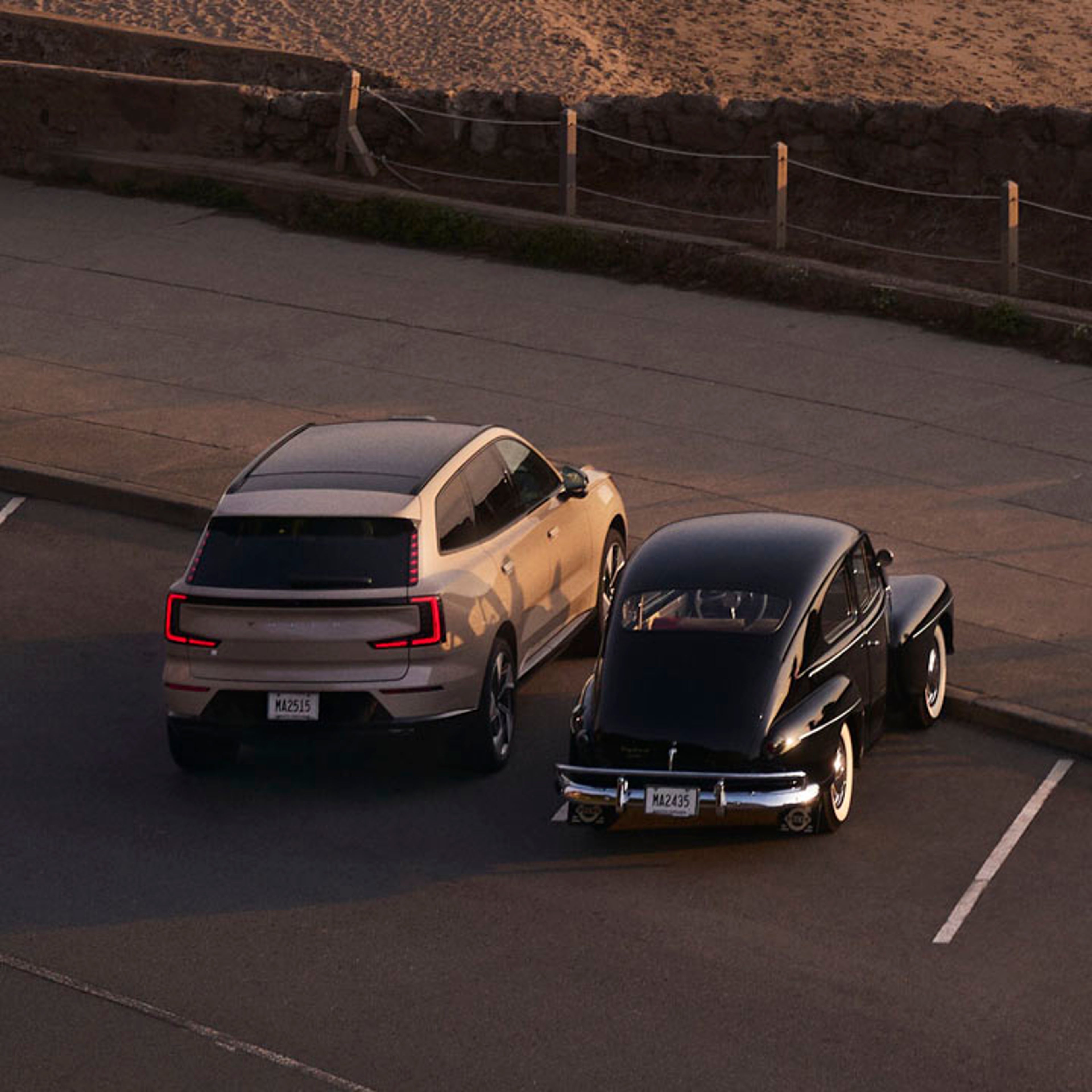 Un Volvo eléctrico junto a un Volvo clásico en una playa junto al mar