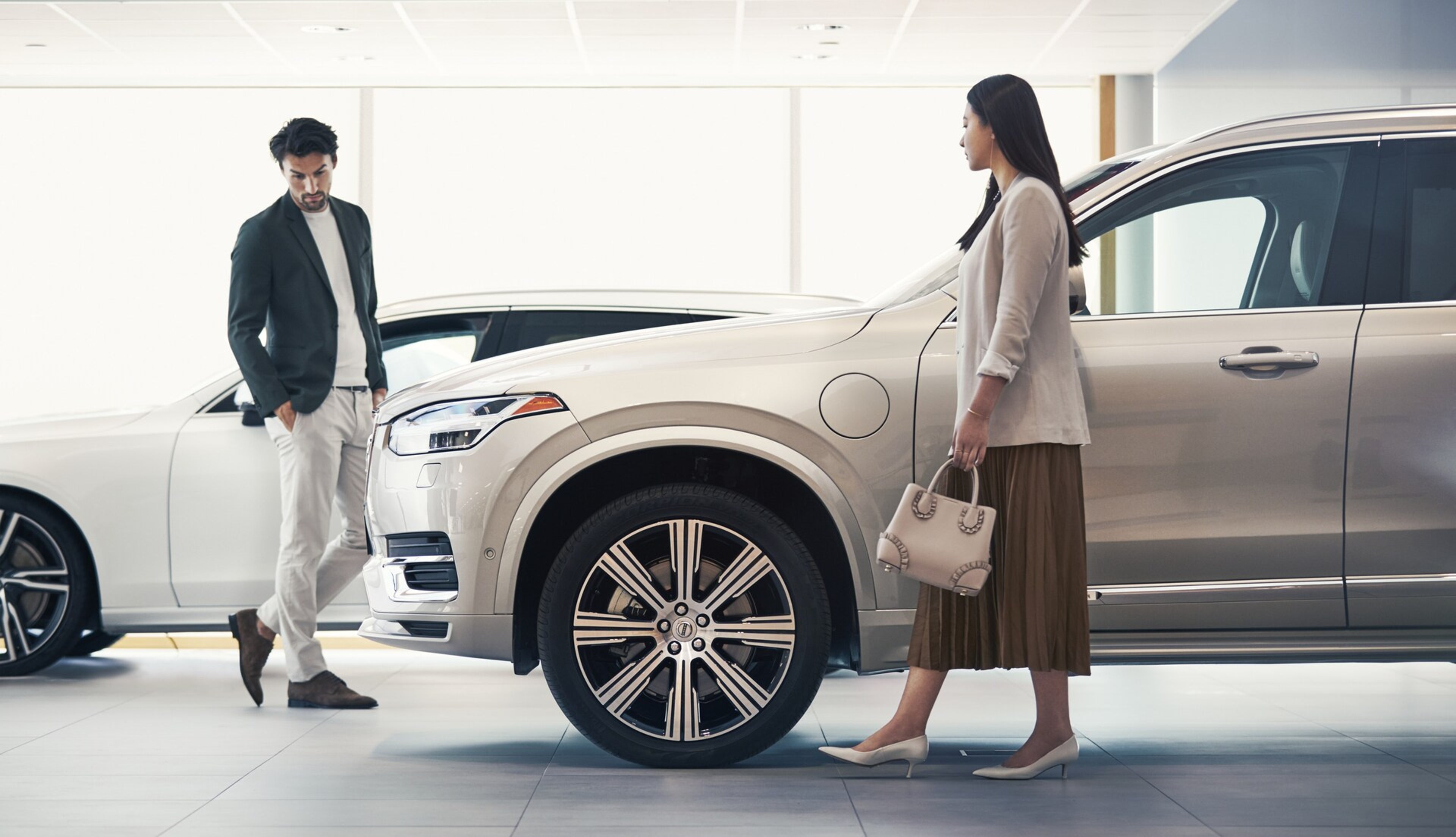 Ügyfelek tekintenek meg egy Volvo modellt egy márkakereskedésben