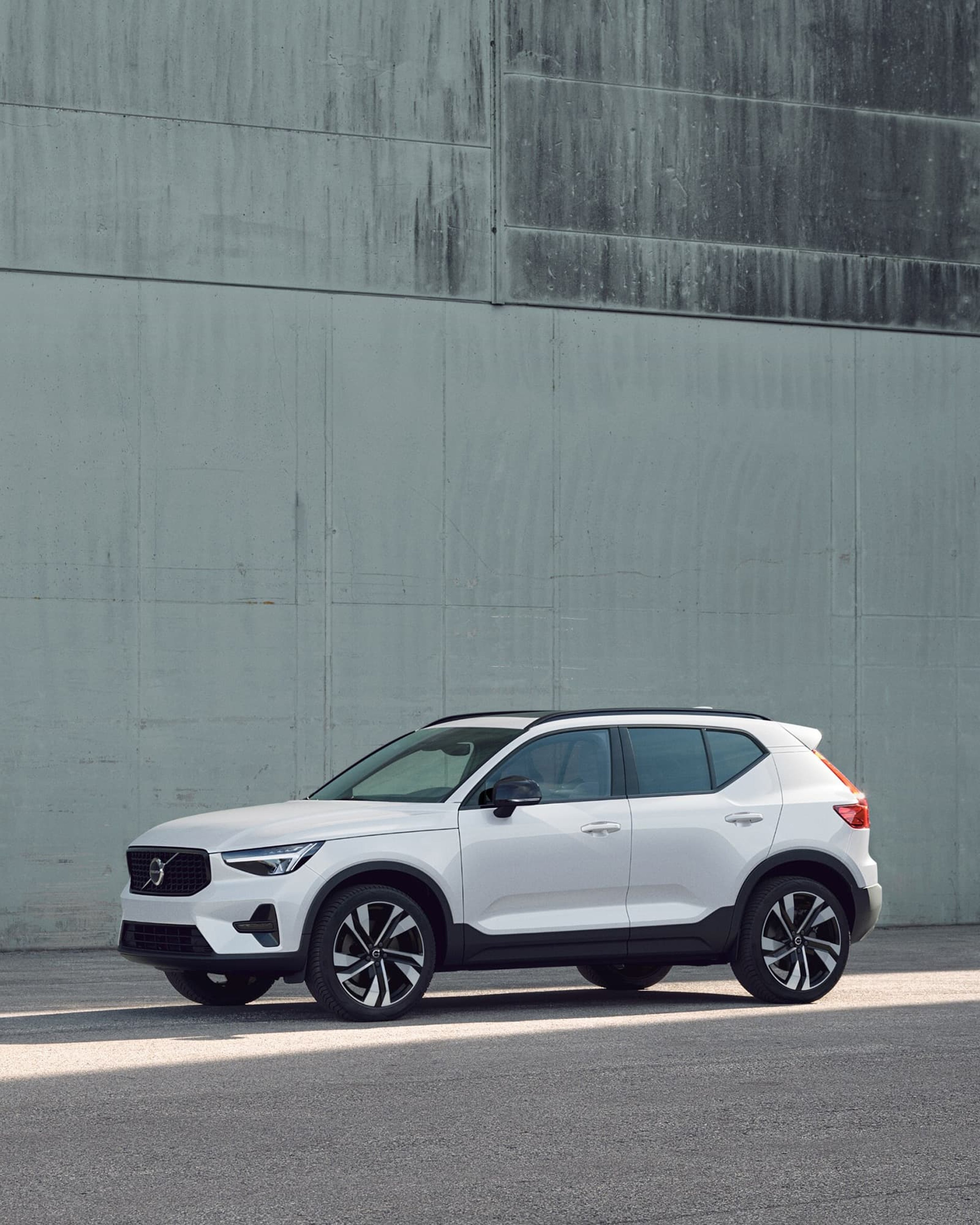Une Volvo XC40 Ultra blanche garée contre un mur vert