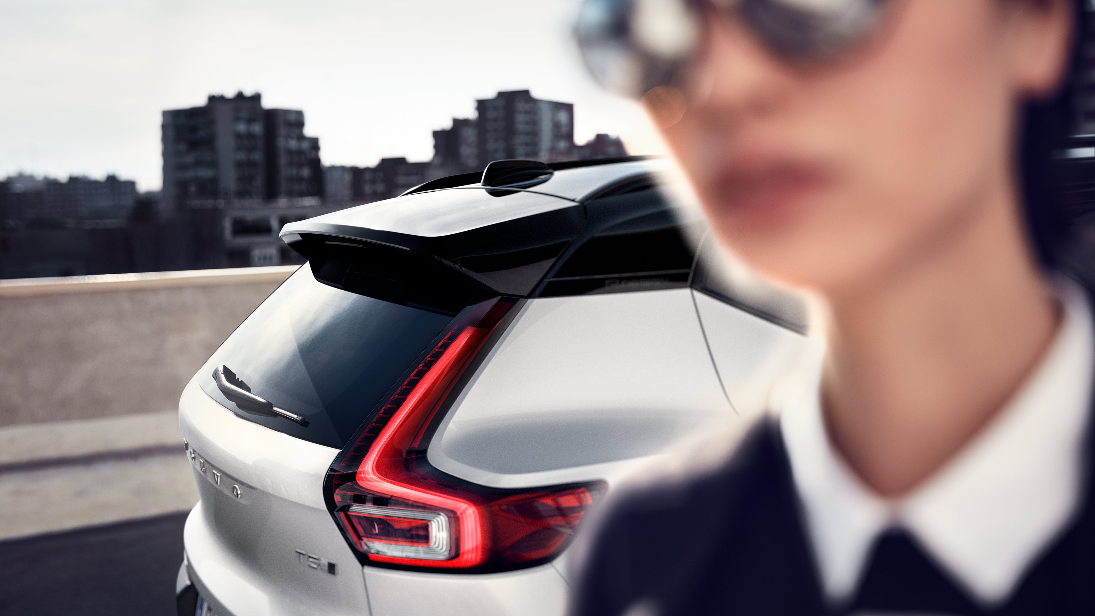 Femme devant l'arrière d'une voiture Volvo
