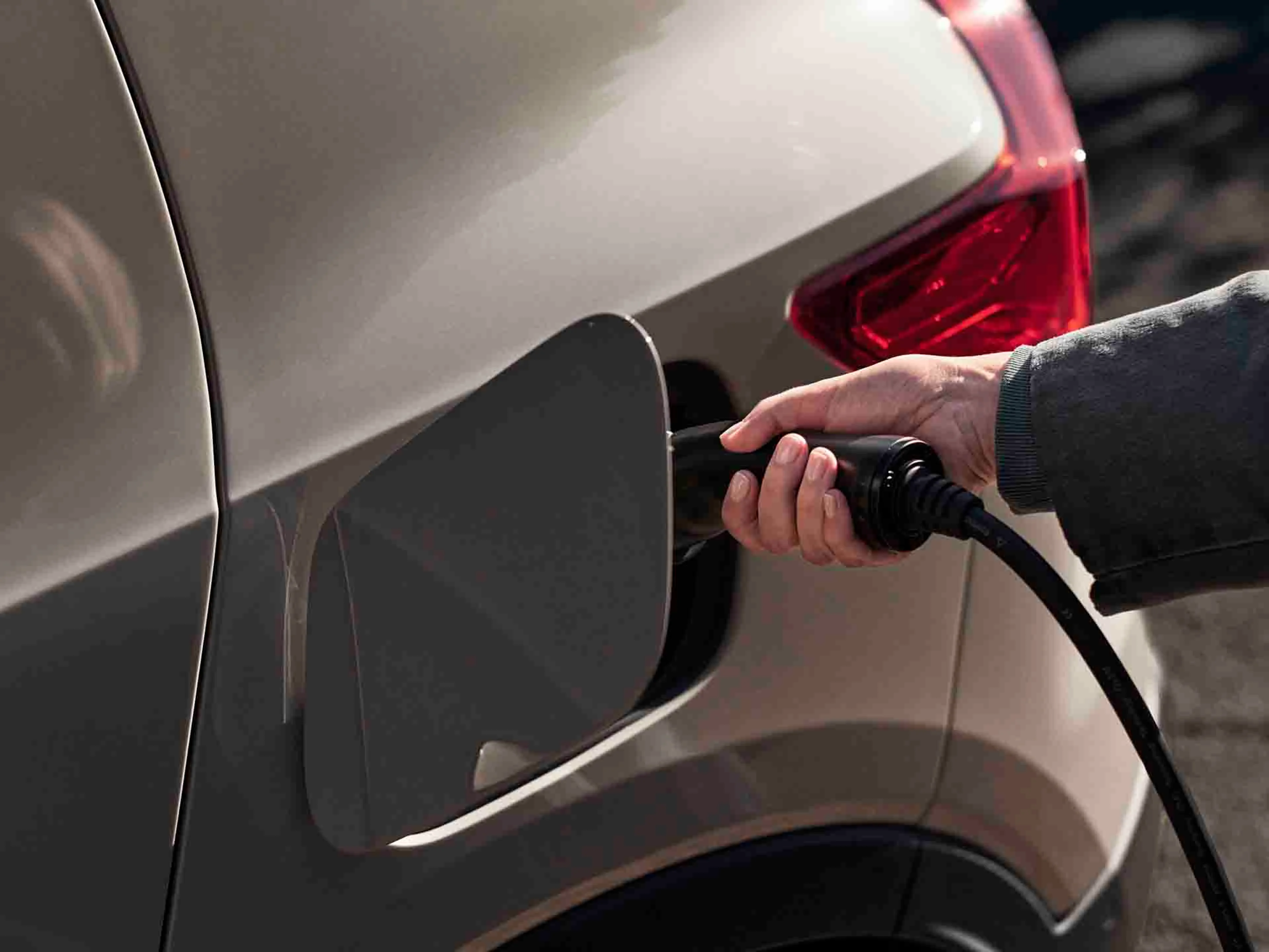 Un Volvo EX40 eléctrico y una mano cargándolo