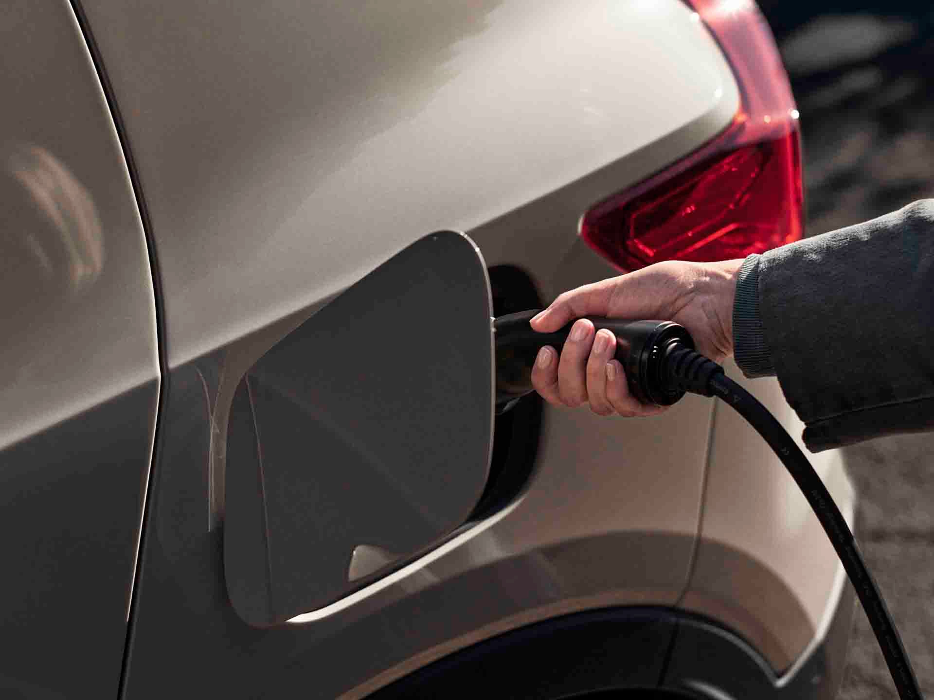 Un Volvo EX40 eléctrico y una mano cargándolo