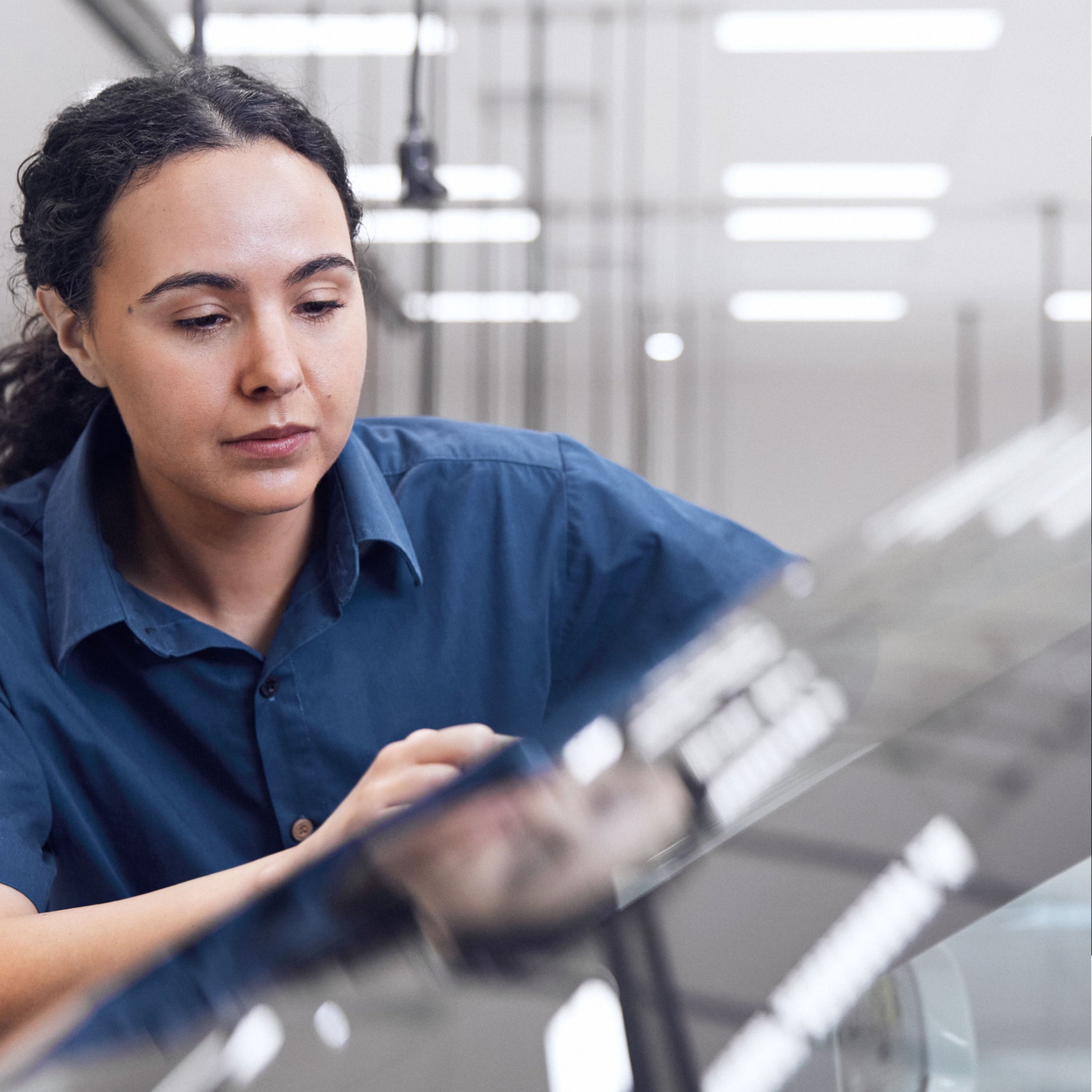 Pracovnice servisu opravuje čelní sklo vozu Volvo