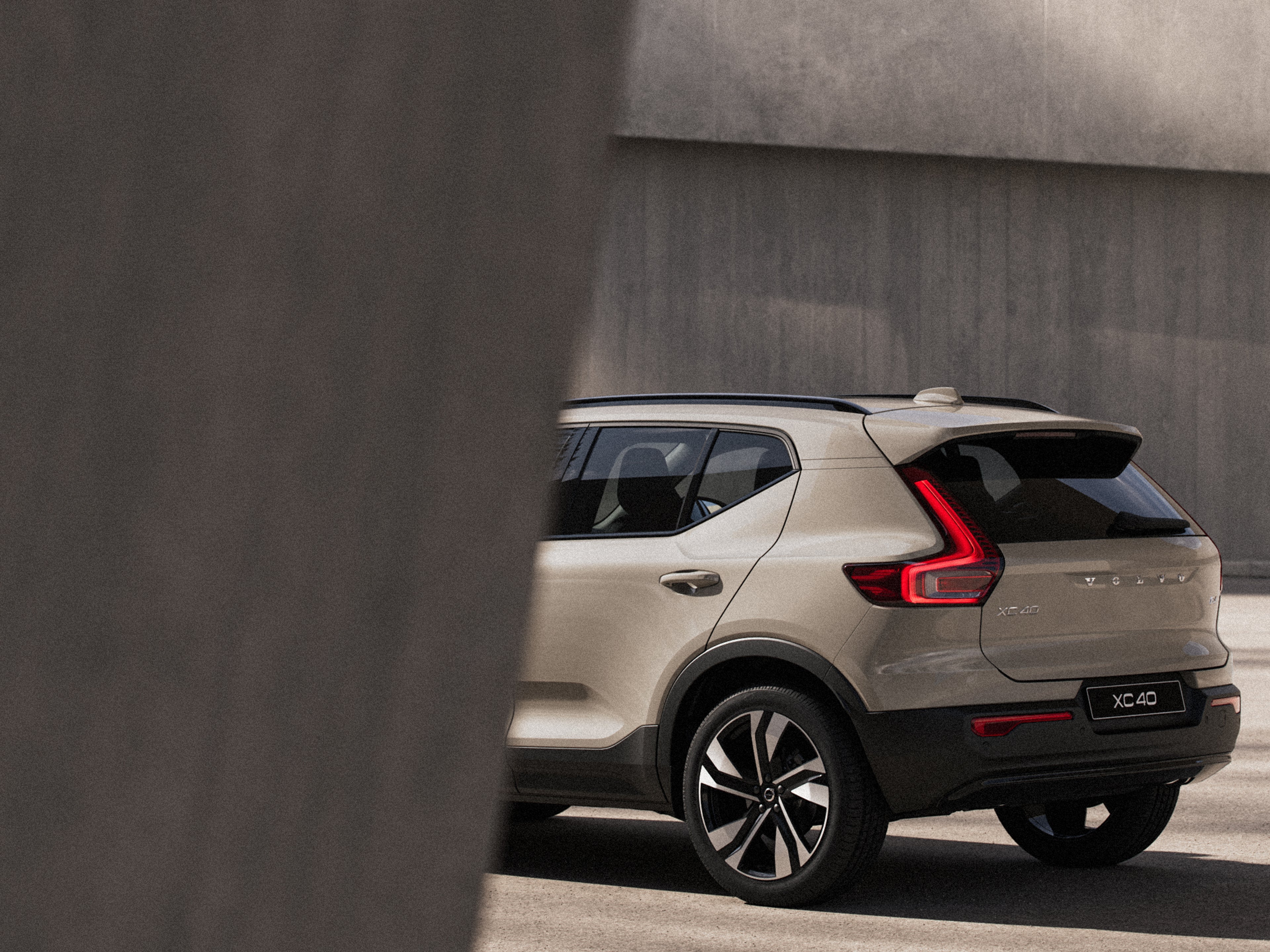 Homokszínű XC40 oldalsó hátsó nézete.