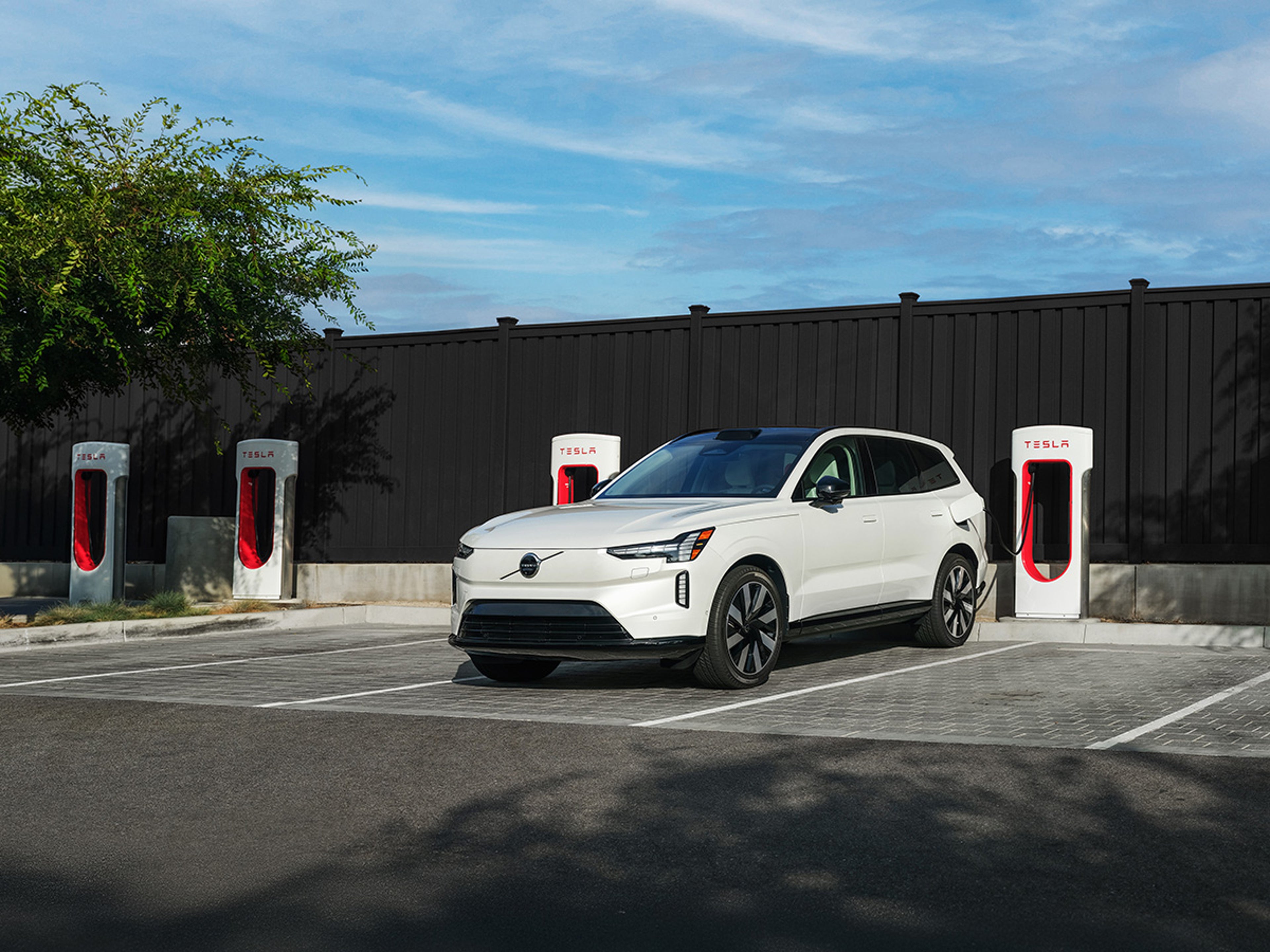 EX90 charging at a Tesla Supercharger