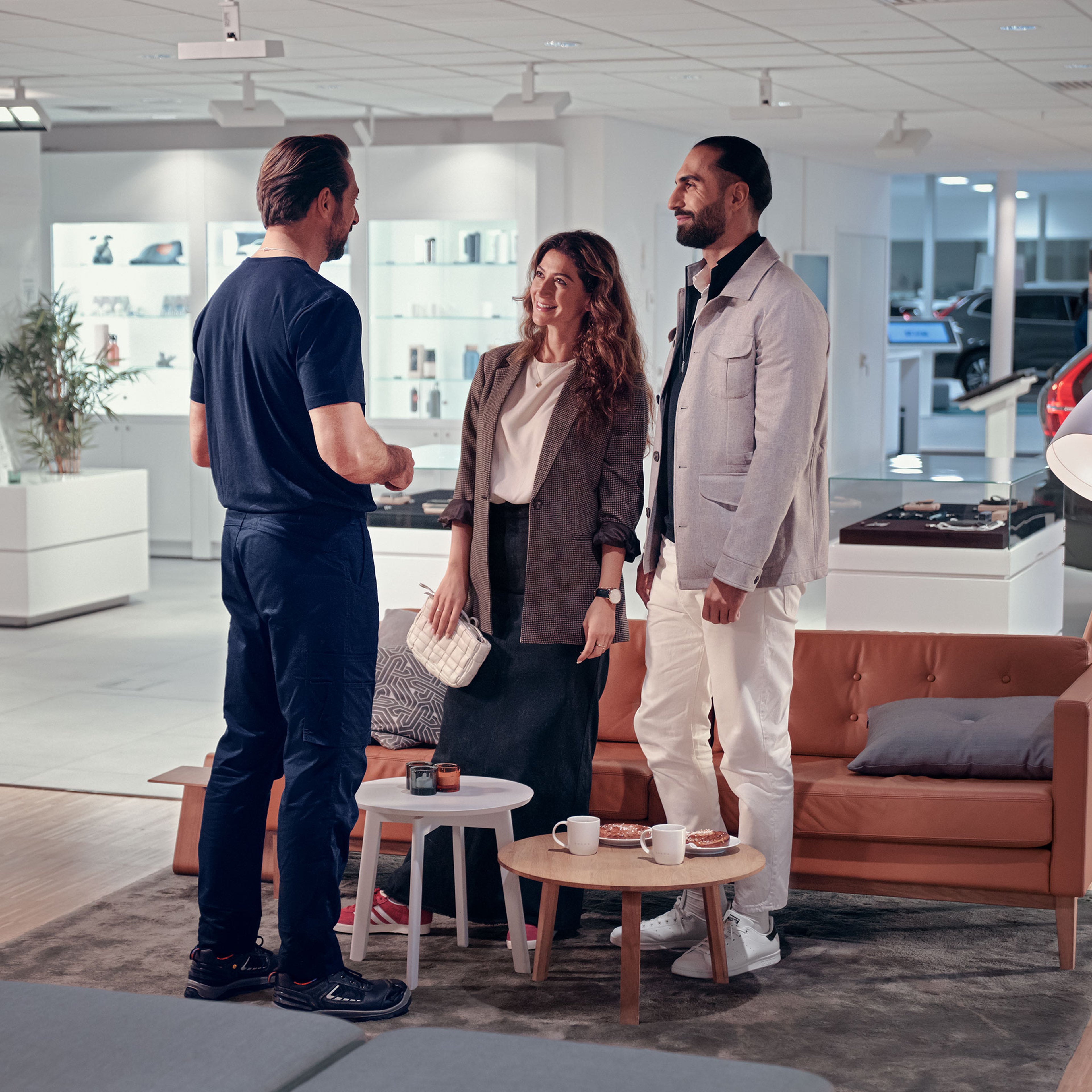 Volvo Omamekaanikko juttelee asiakkaiden kanssa Volvo Personal service huollon odotustilassa.