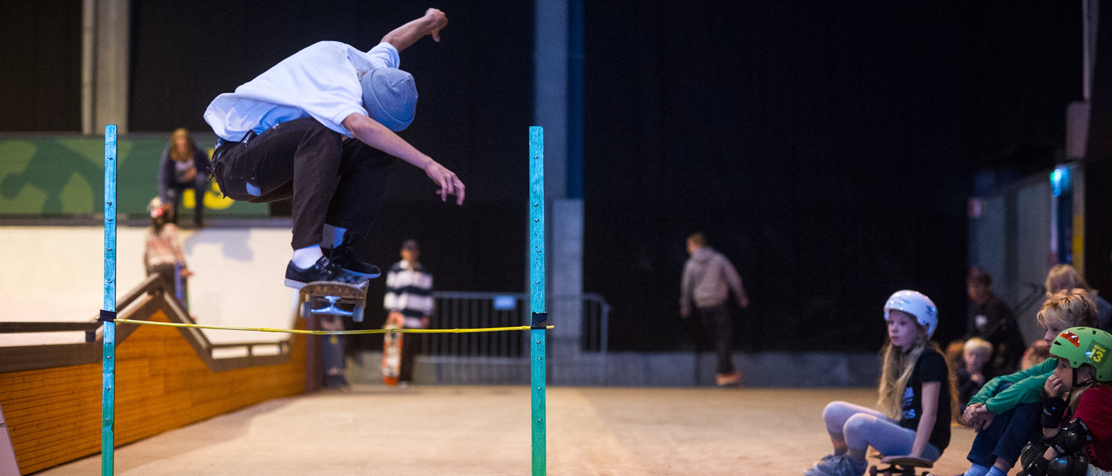 En som hopper på skateboard inne på Skur