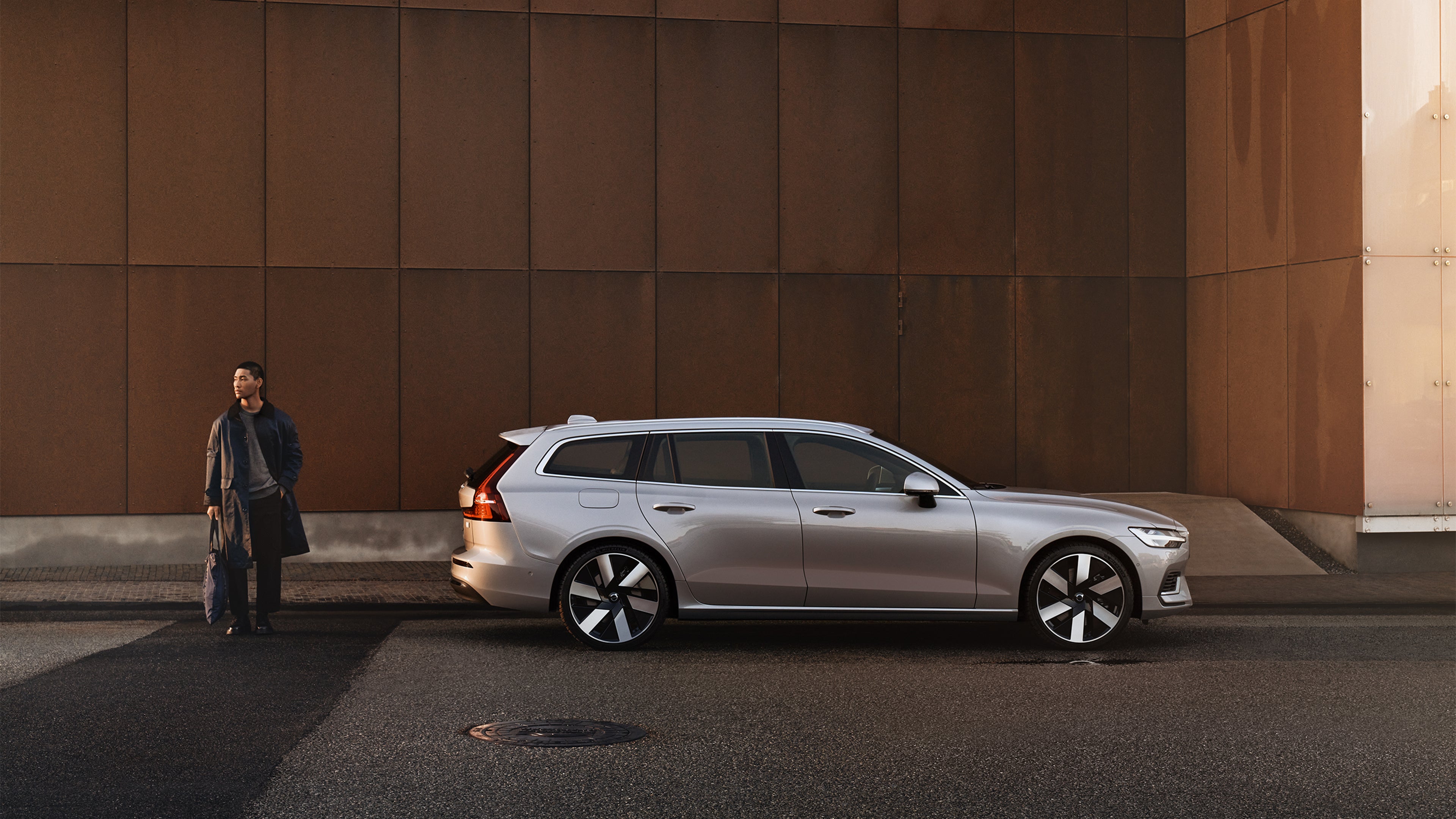 Ein silbernes Volvo Fahrzeug parkt vor einer braunen Wand.