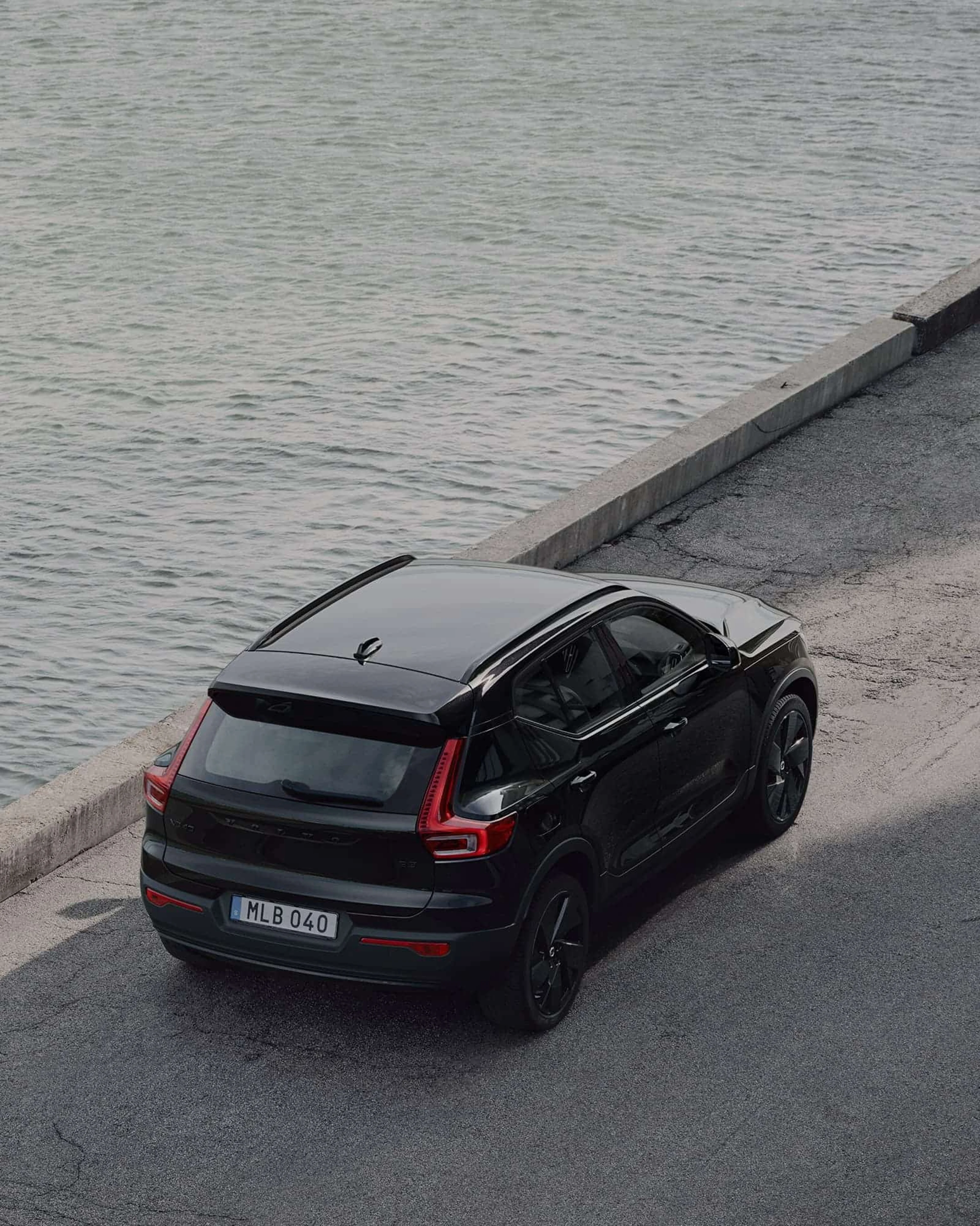 Zwarte Volvo XC40 Black Edition geparkeerd langs het water