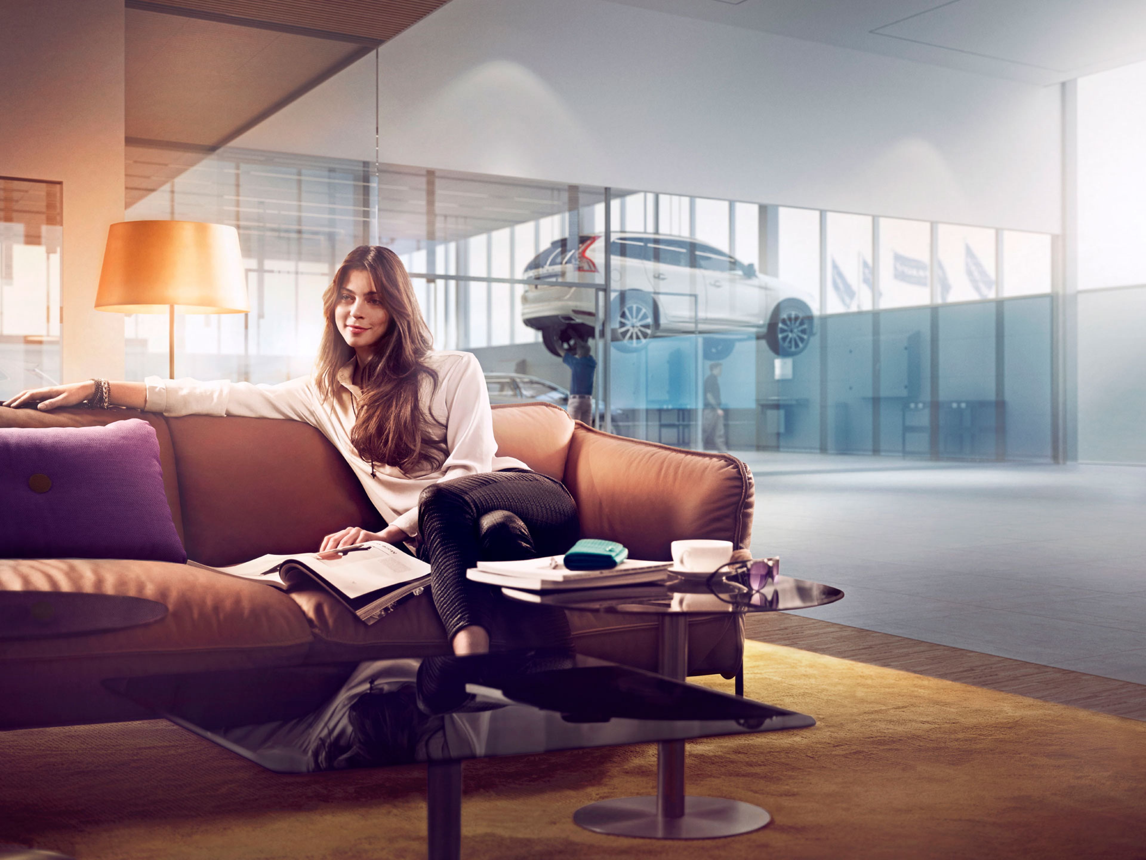 Una mujer sentada en una sala de espera de un centro de servicio Volvo