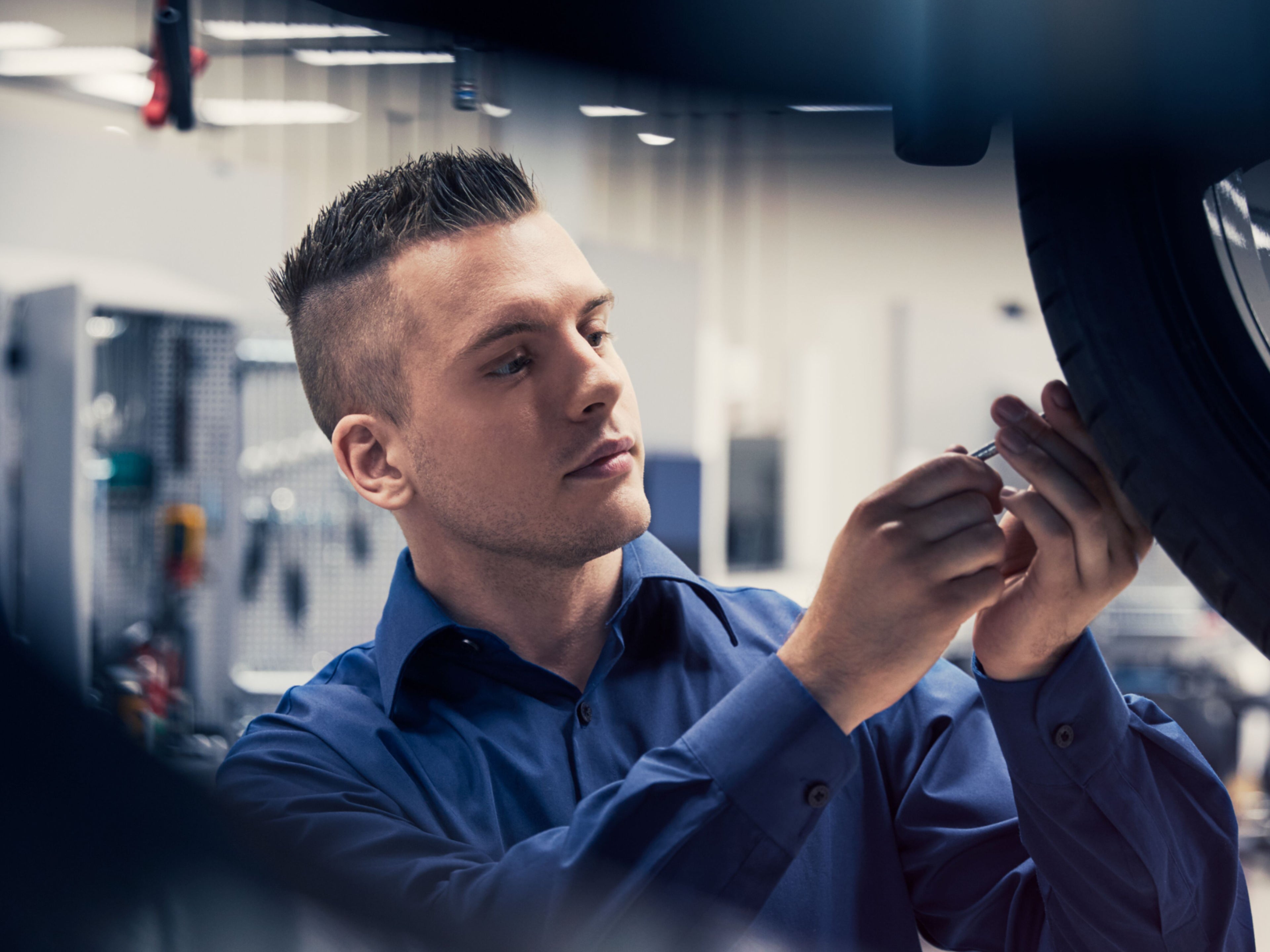 Ein Volvo Mitarbeiter überprüft einen Reifen eines Volvo Fahrzeugs.