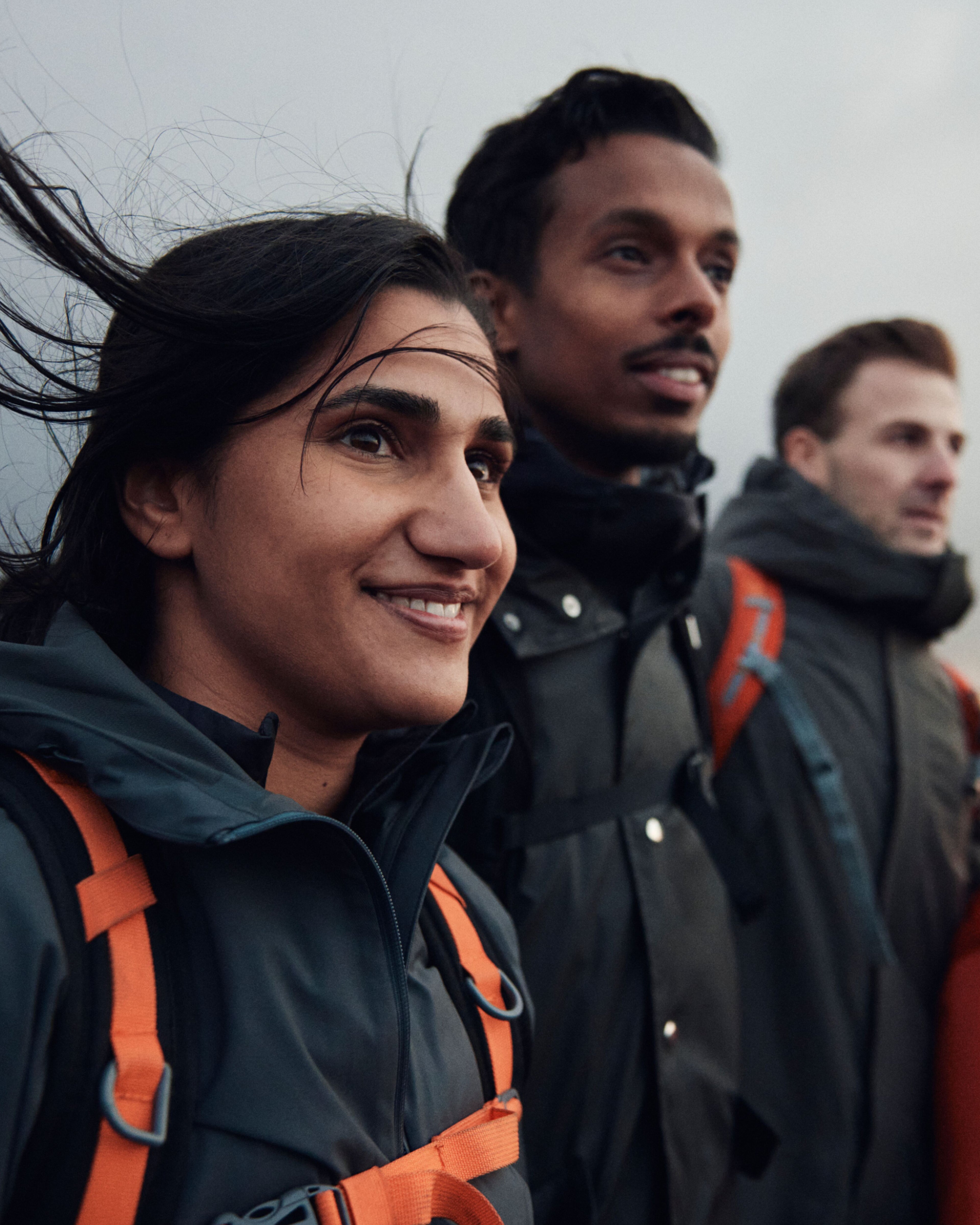 Zwei Männer und zwei Frauen stehen nebeneinander und in die Ferne