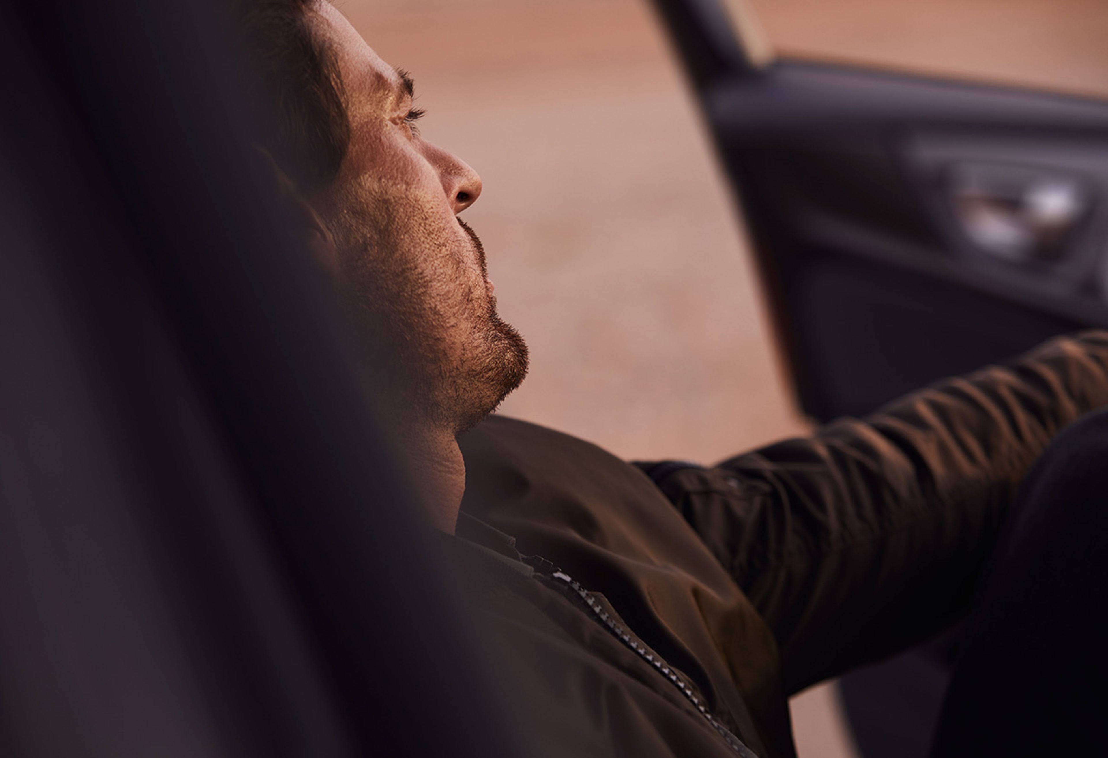 Ein Mann sitzt auf der Fahrerseite eines Volvo und blickt aus der geöffneten Fahrzeugtür.