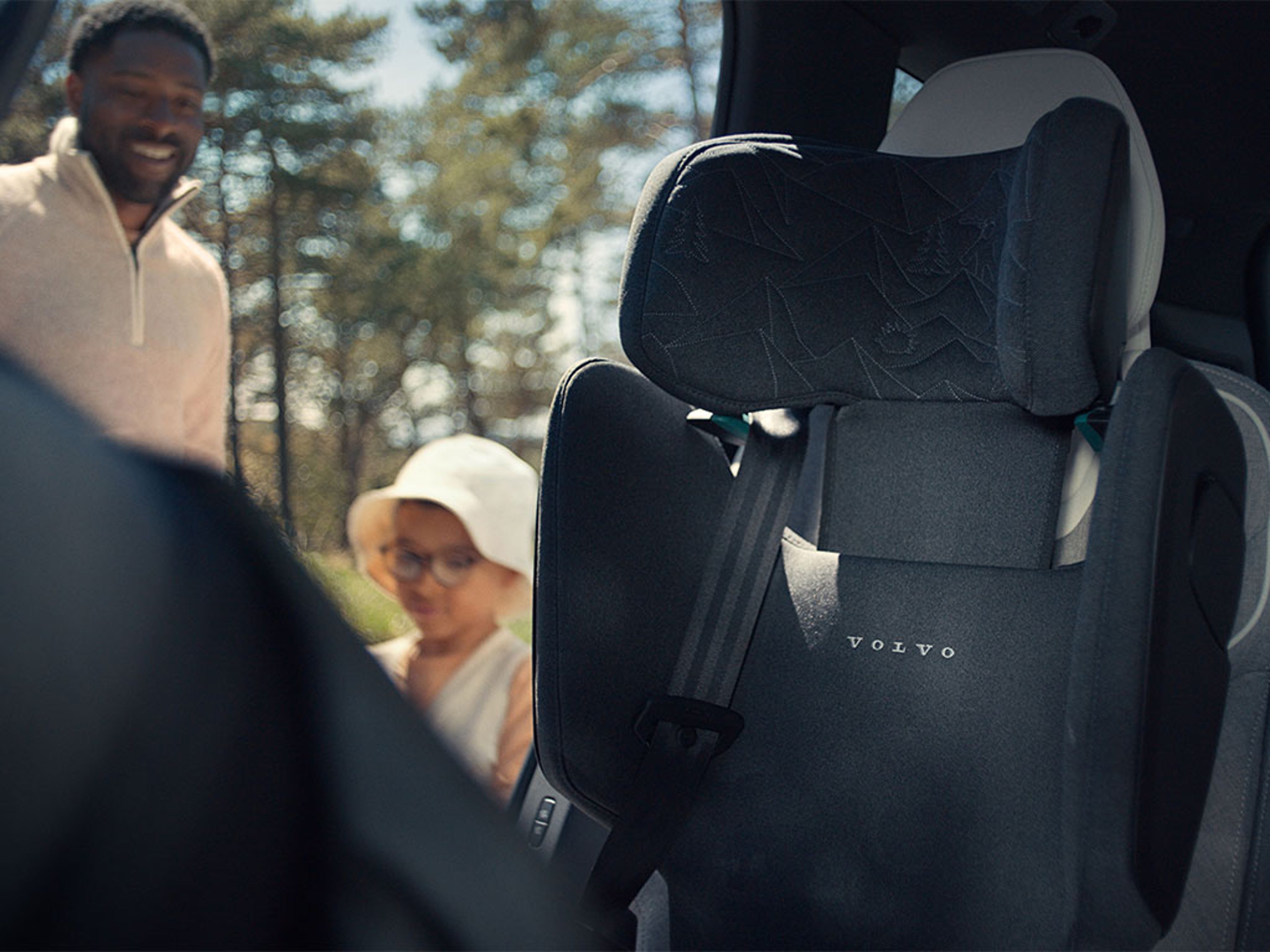 Père et son enfant s’apprêtant à s’installer dans le siège enfant d’une Volvo