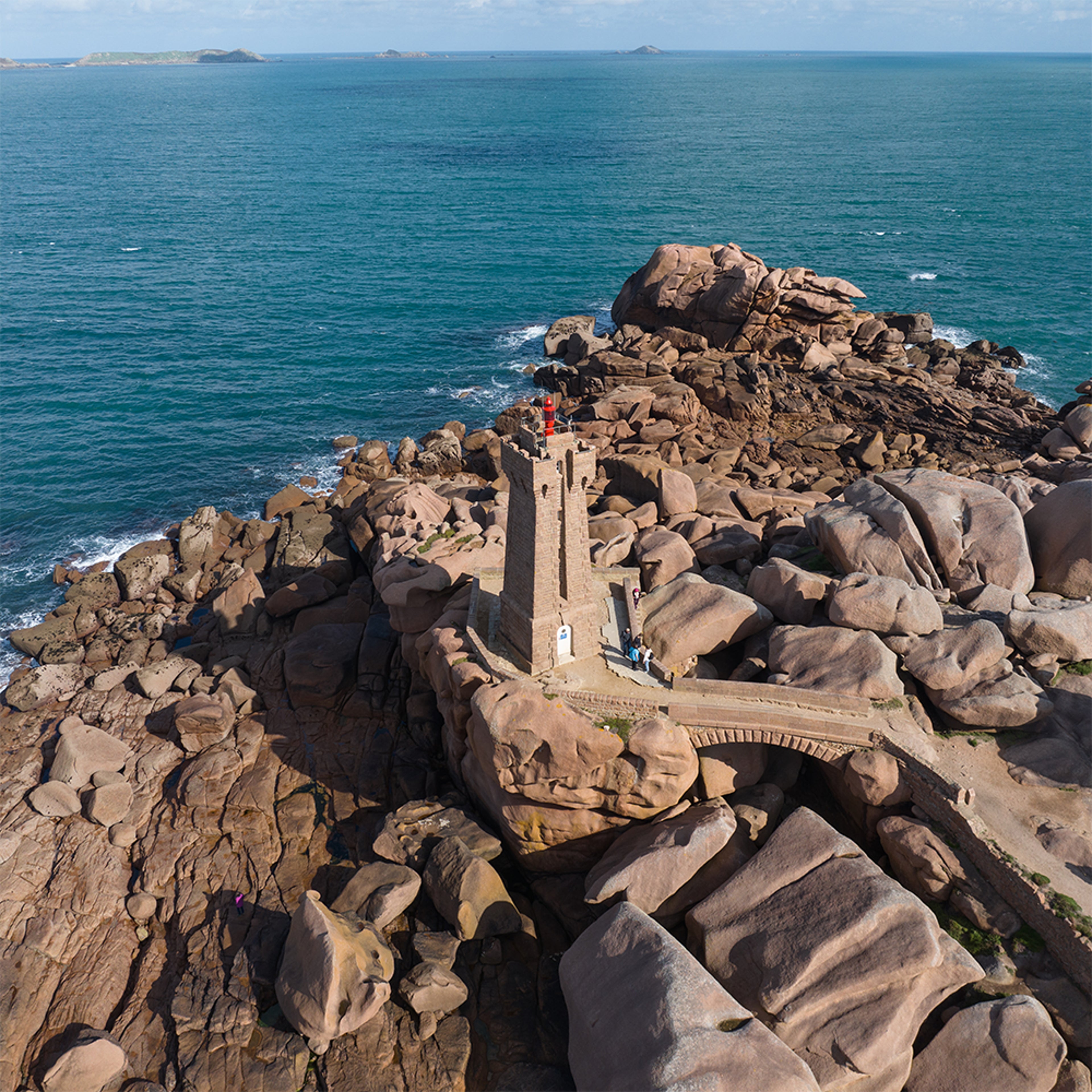 Phare de Ploumanac’h sur côte de granit rose, entouré de rochers, vue sur l’océan Atlantique.