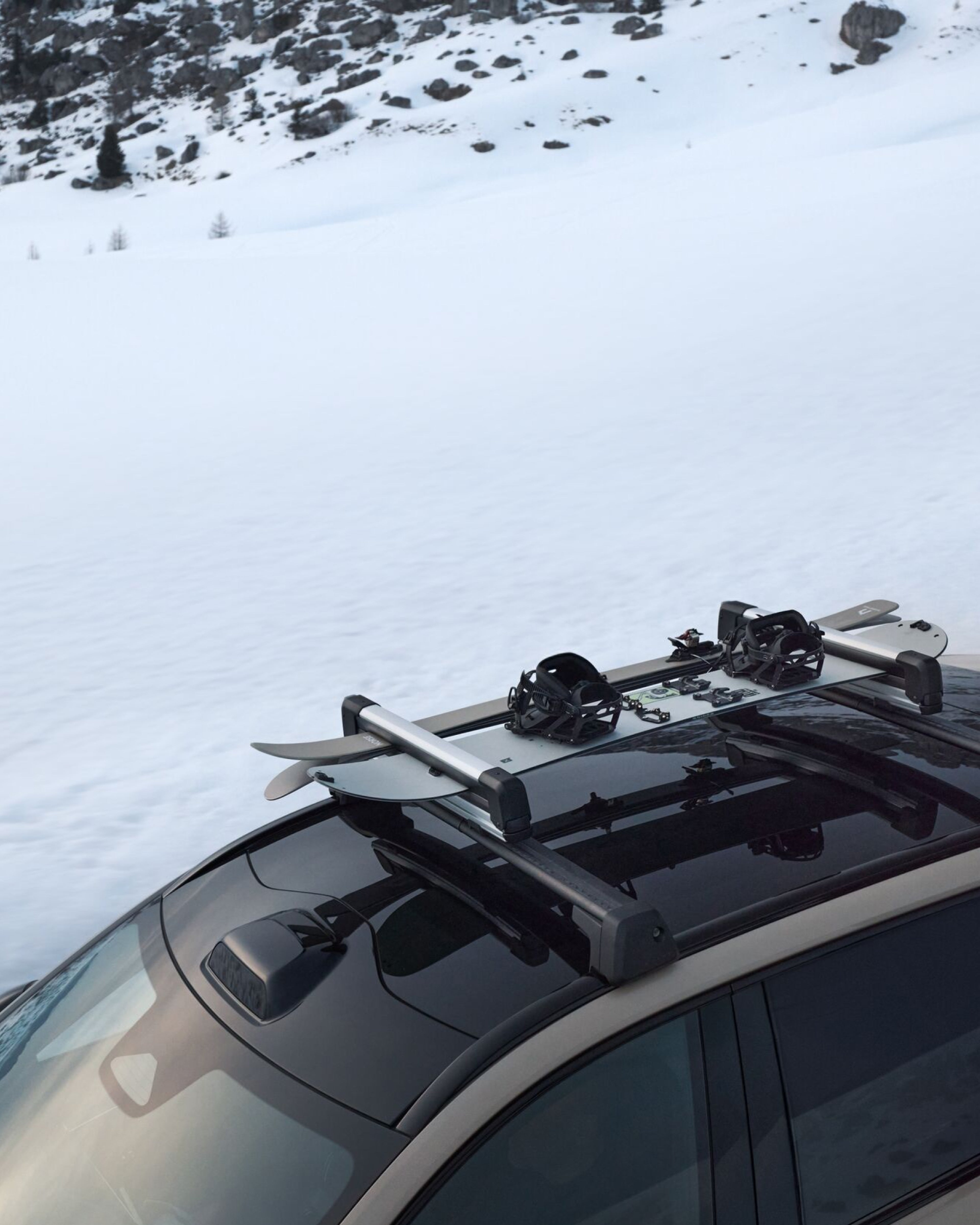 Volvo EX90 avec porte-skis sur le toit avec un snowboard