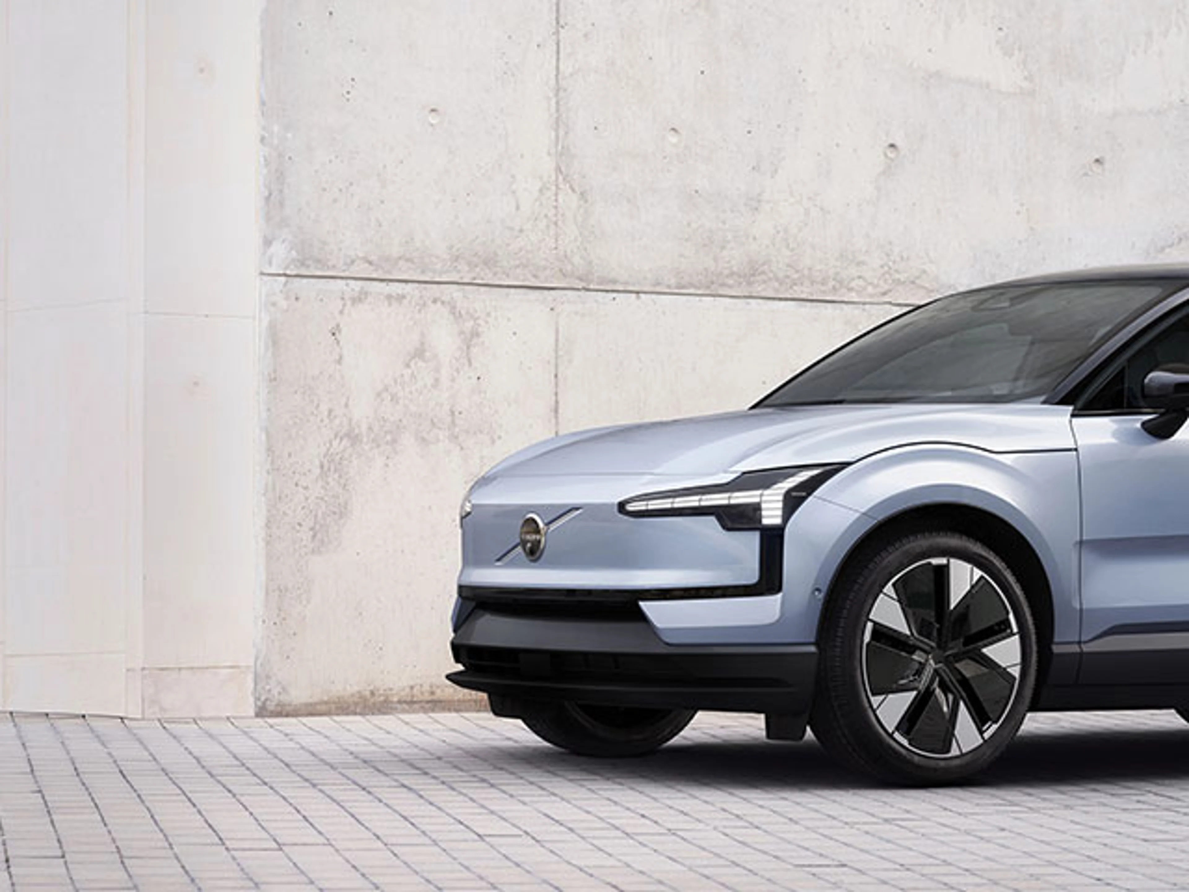 Ein Ausschnitt des vorderen Teil eines silbernen Volvo EX30 SUV.