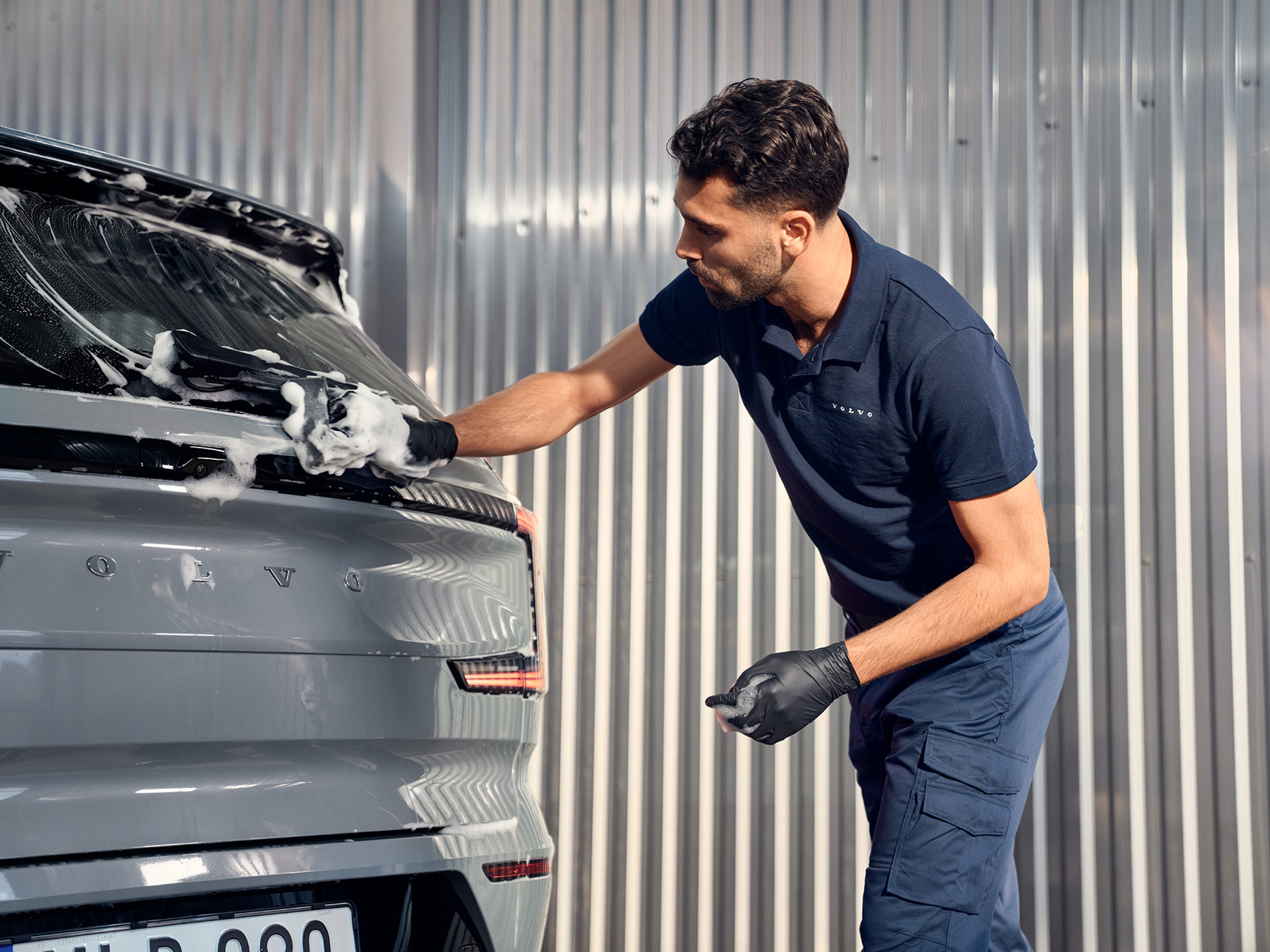 Funcionário Volvo a fazer uma limpeza num volvo EX90, numa oficia