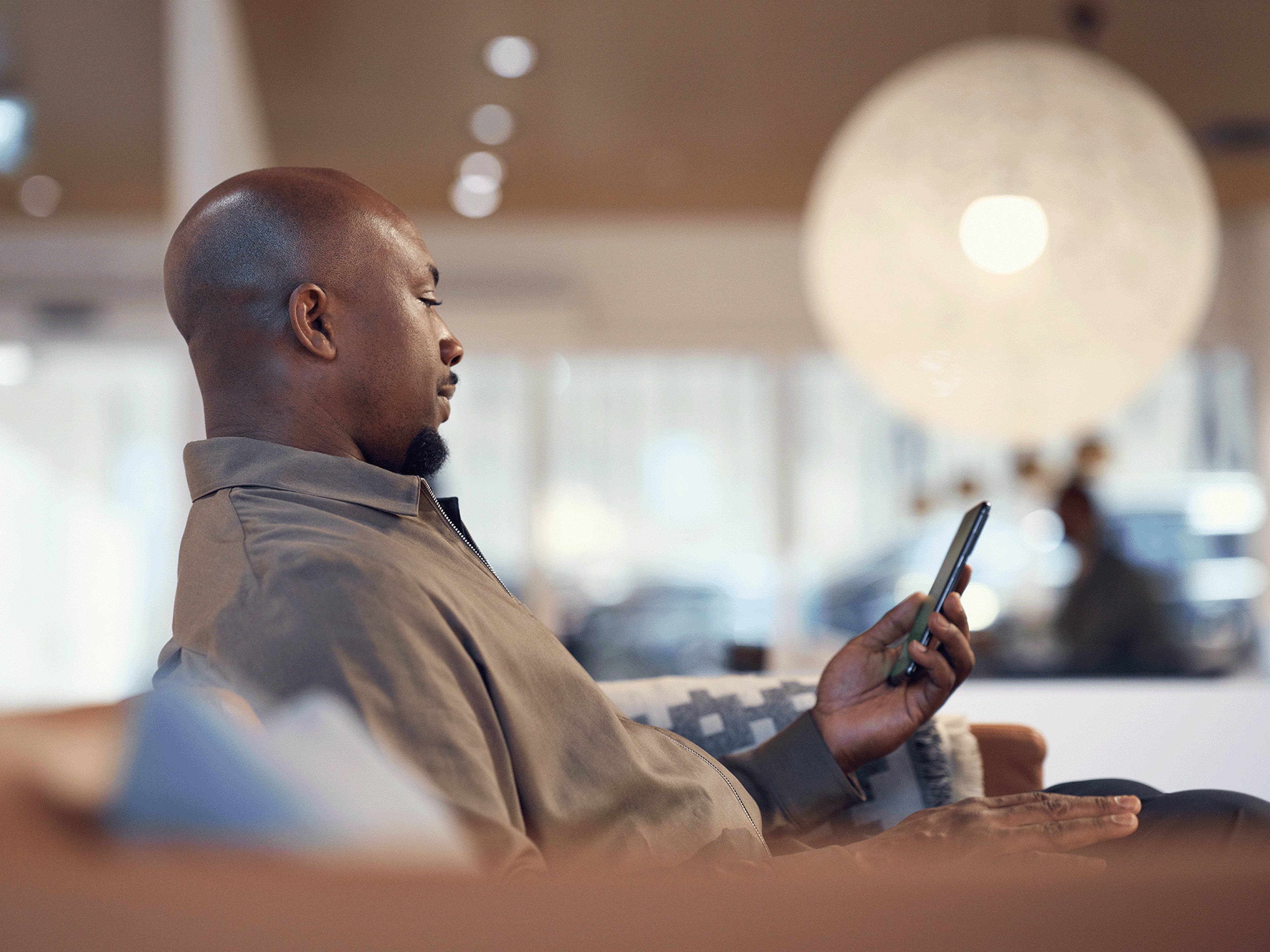 Ein Volvo Kunde schaut auf sein Smartphone.