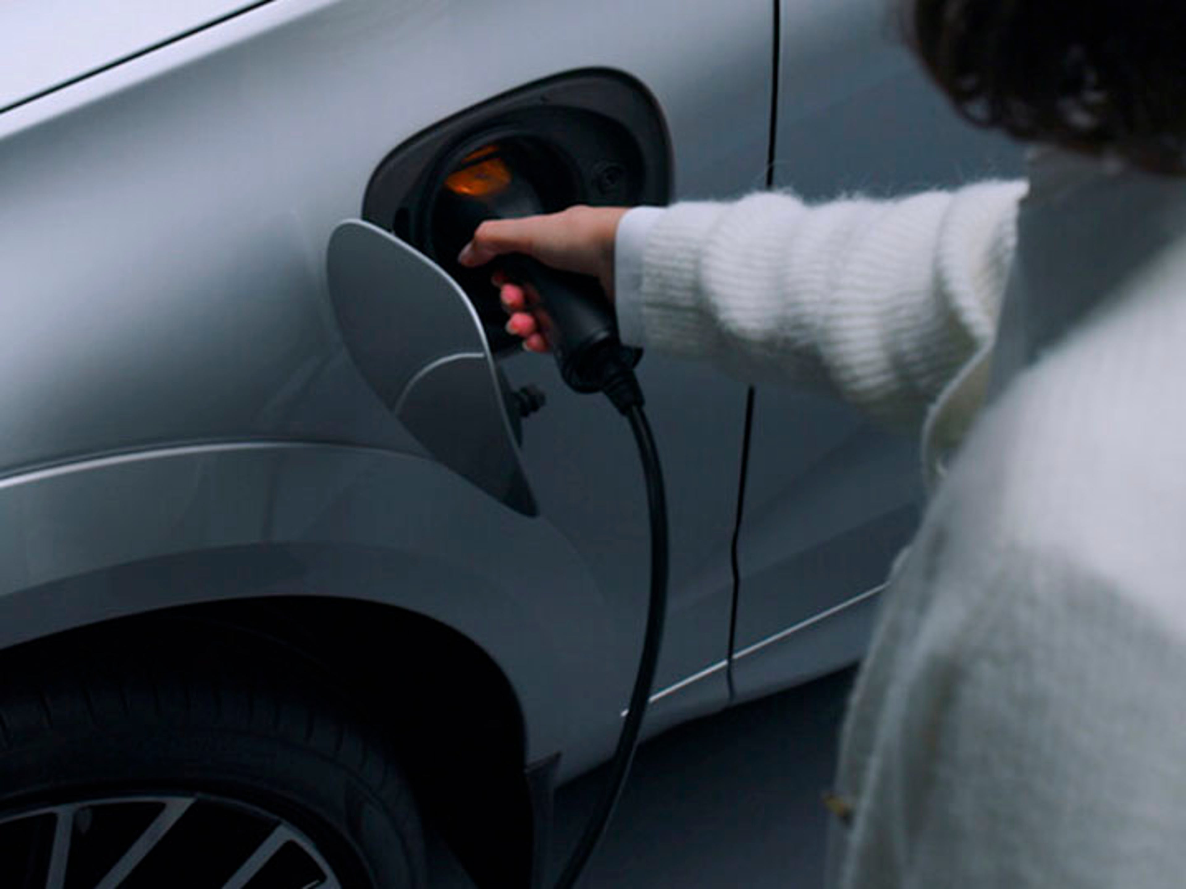 Una persona cargando un vehículo Volvo eléctrico