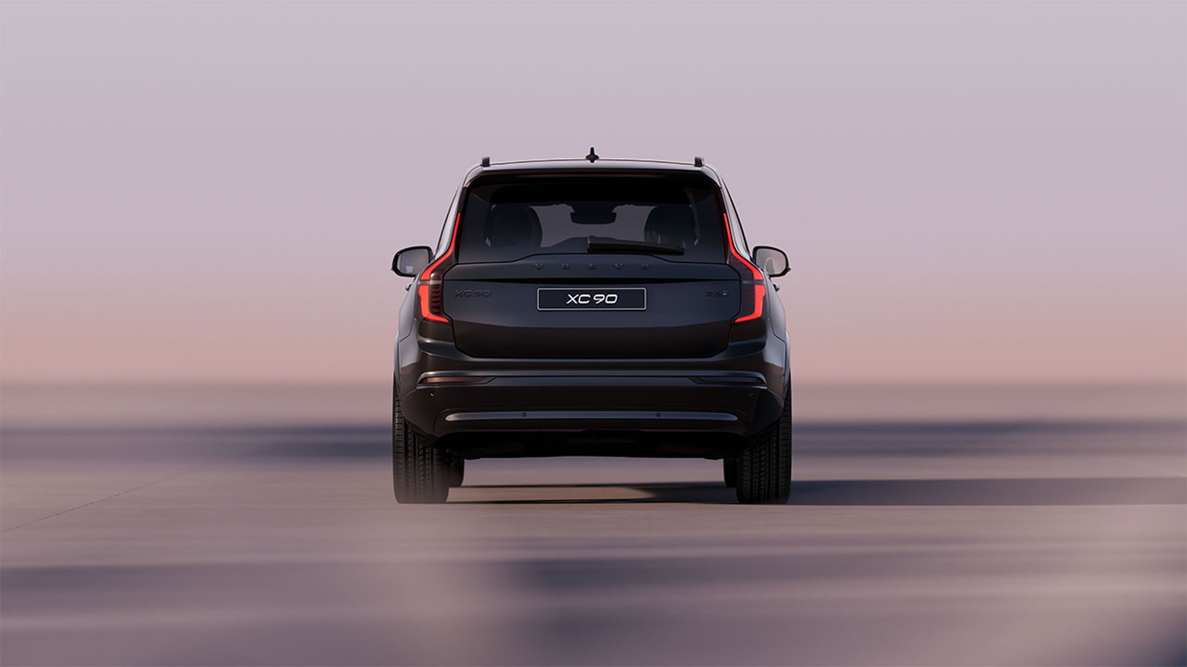 Vue arrière d’un Volvo XC90 Black Edition sur route lisse avec arrière-plan flou.