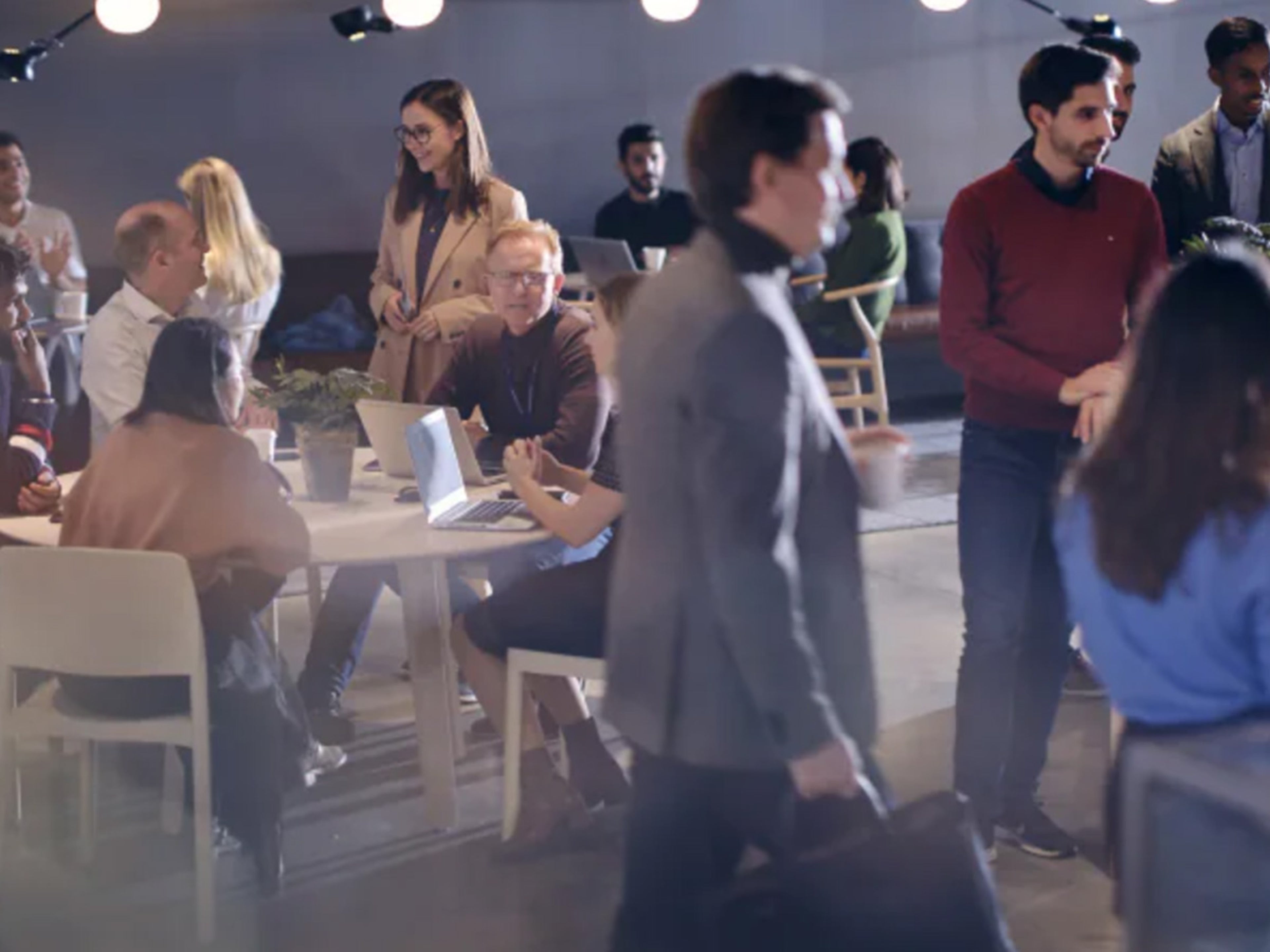 Een diverse groep mensen netwerkt en socialiseert in een moderne kantoorruimte.