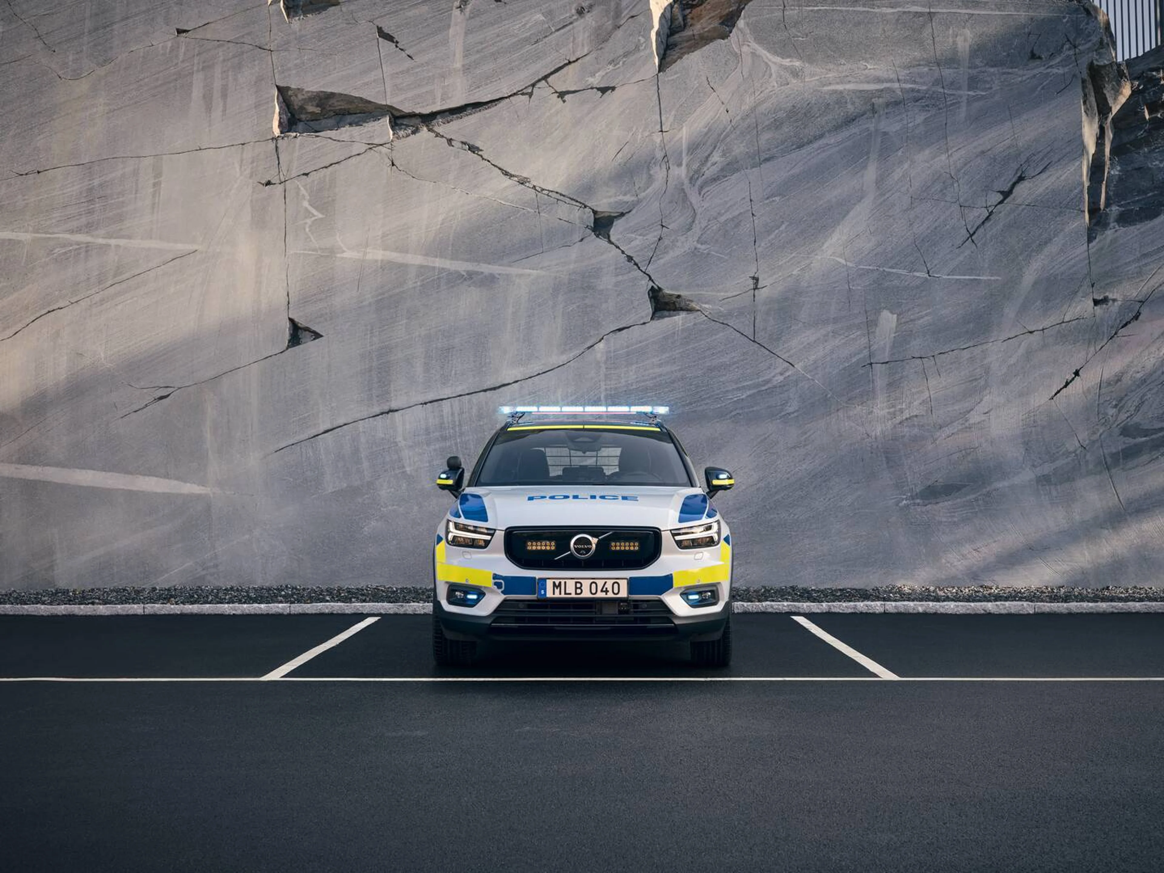 En bil fra Volvo ses direkte forfra med politimærkater i et ødelagt gråt blok miljø