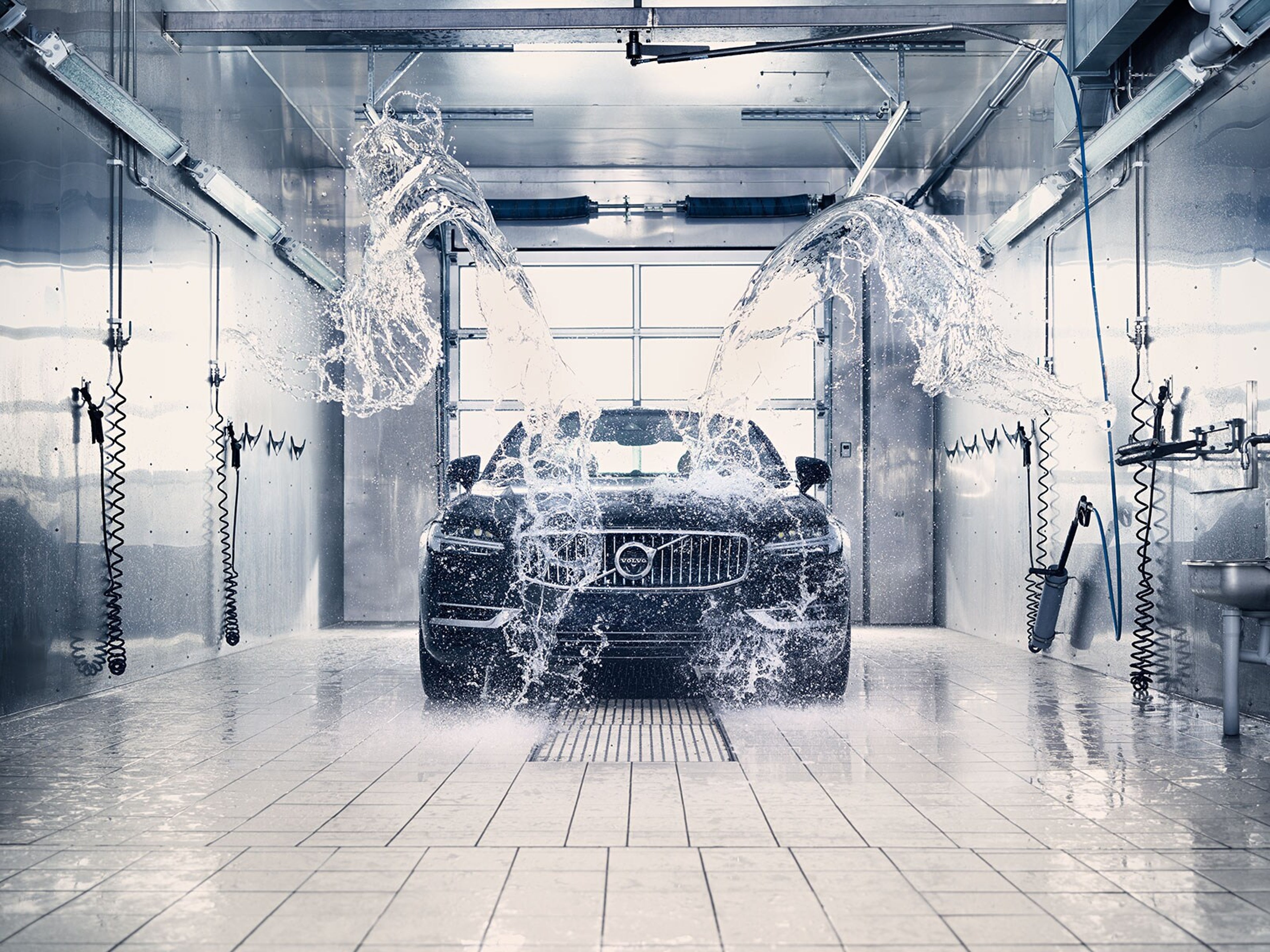 Volvo vozilo u automatskoj praonici tijekom ispiranja vodom