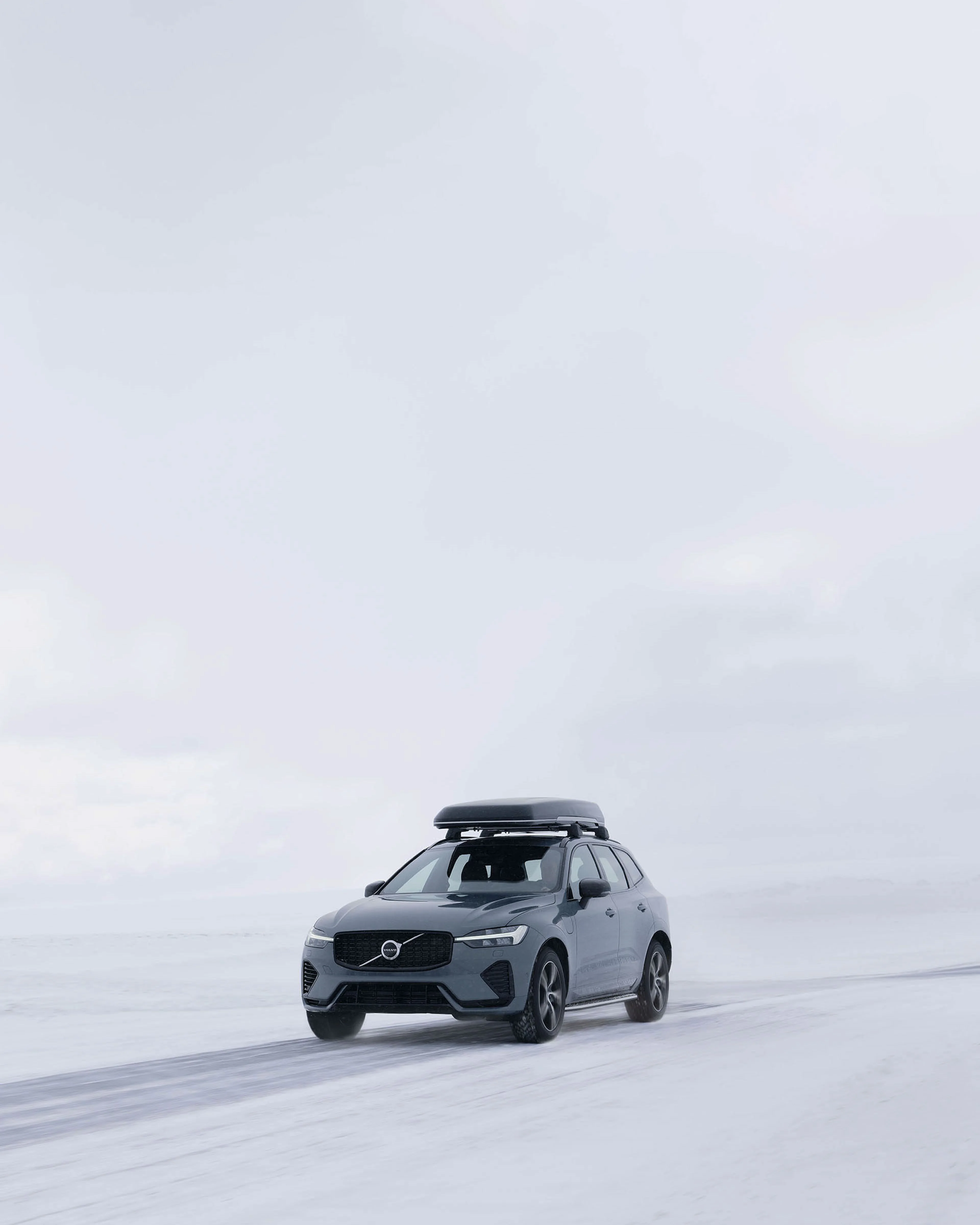 Volvo XC60 met skibox in de sneeuw
