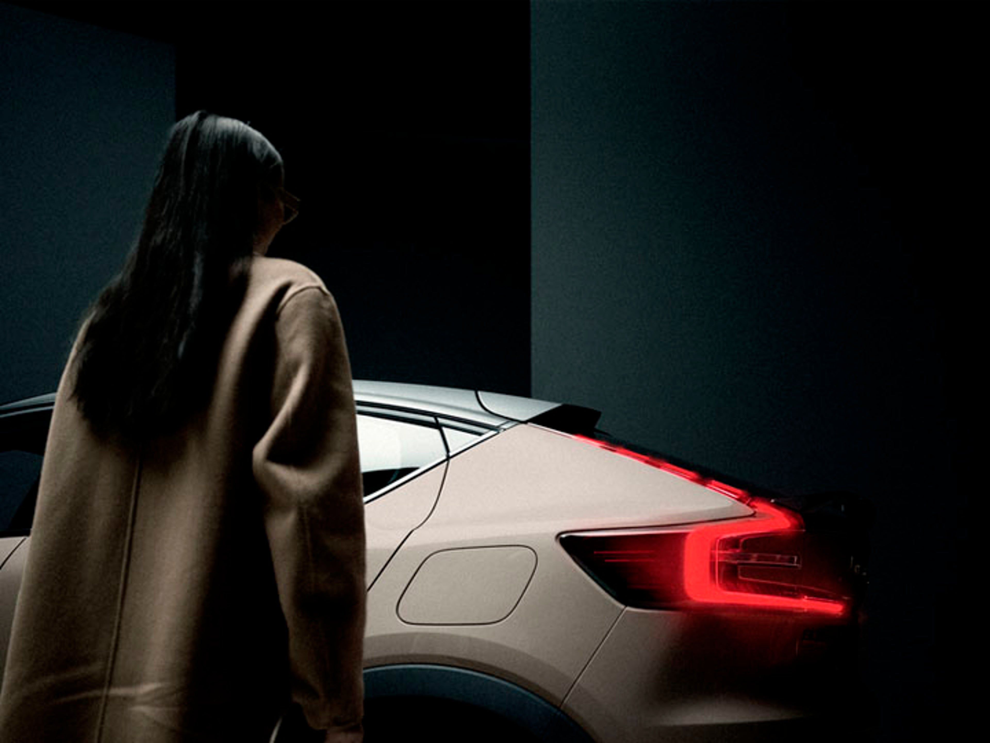 Una mujer despaldas y un Volvo EC40