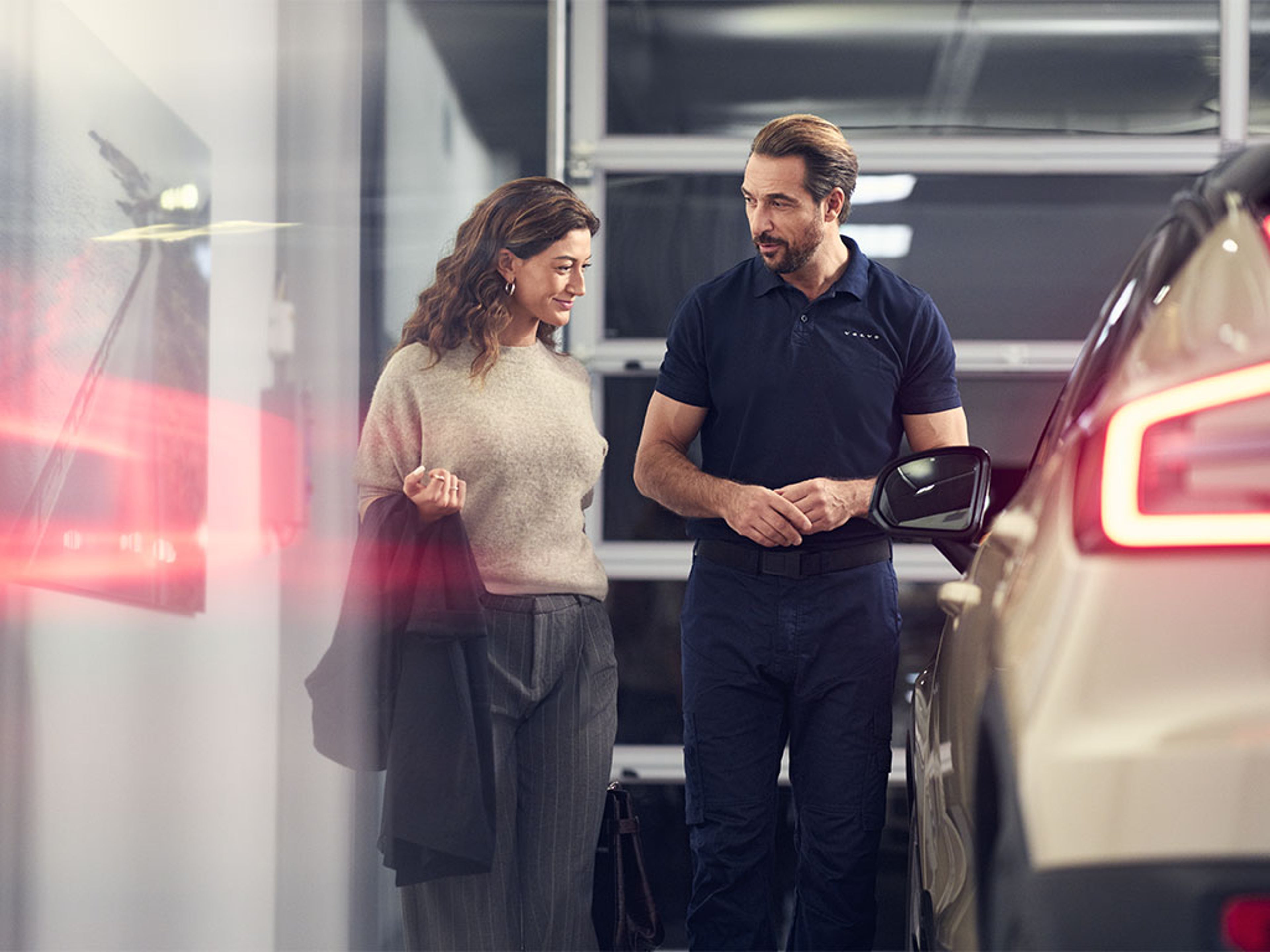 Dans un atelier Volvo, un technicien échange avec une cliente et lui présente le programme Les privilèges V+