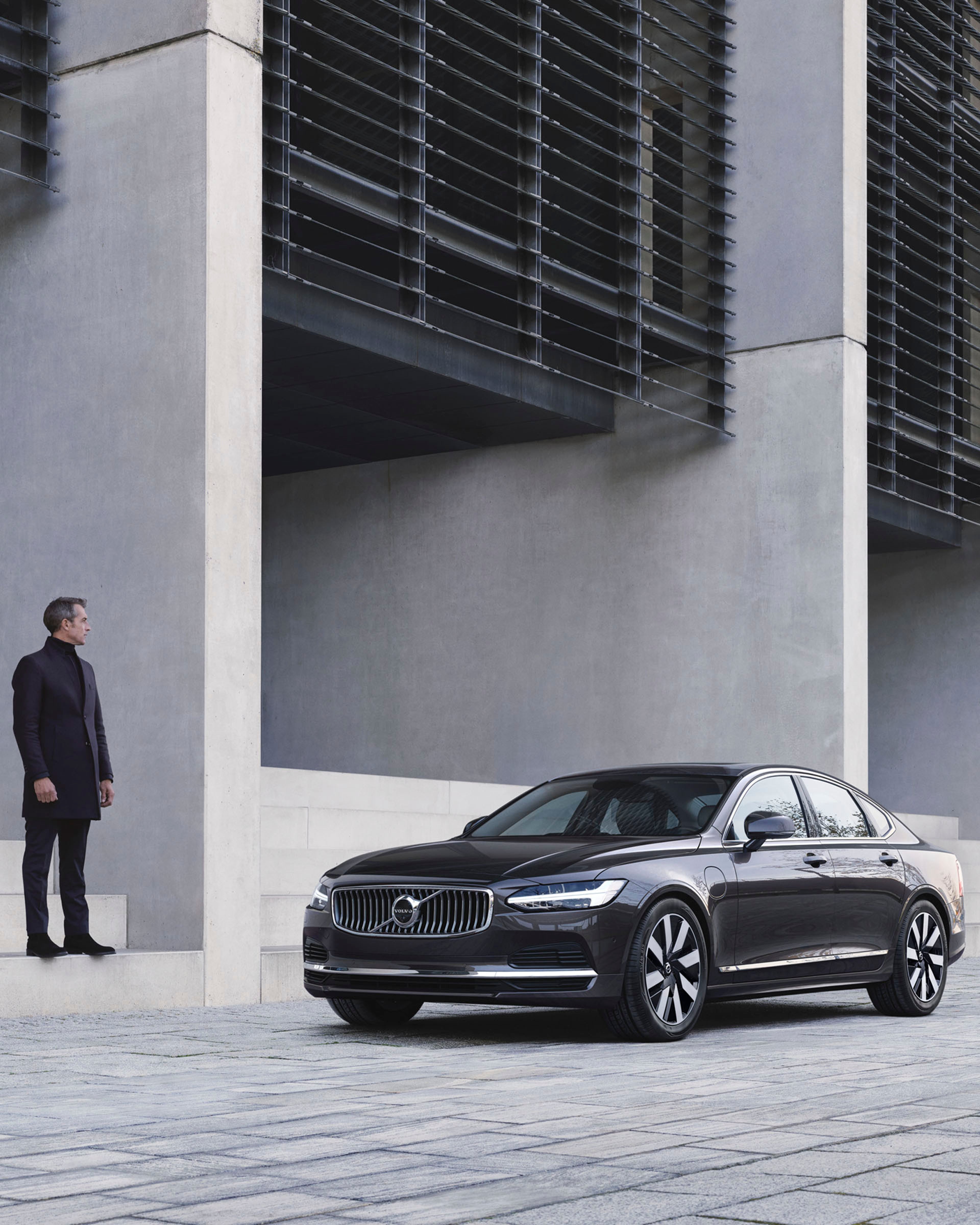 Un hombre en las escaleras observando un Volvo S90