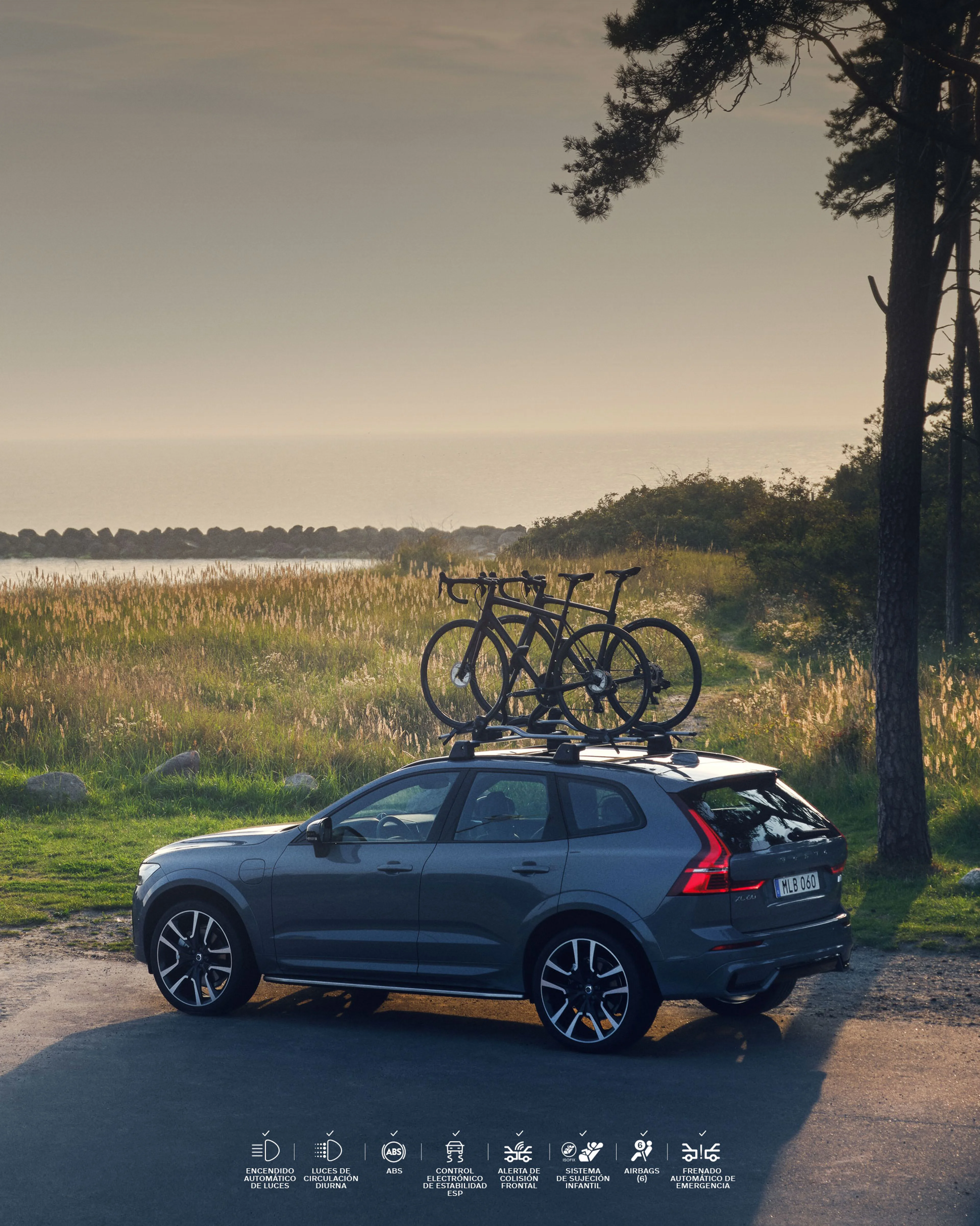 Un Volvo XC60 con portabicicletas estacionado cerca de una playa.