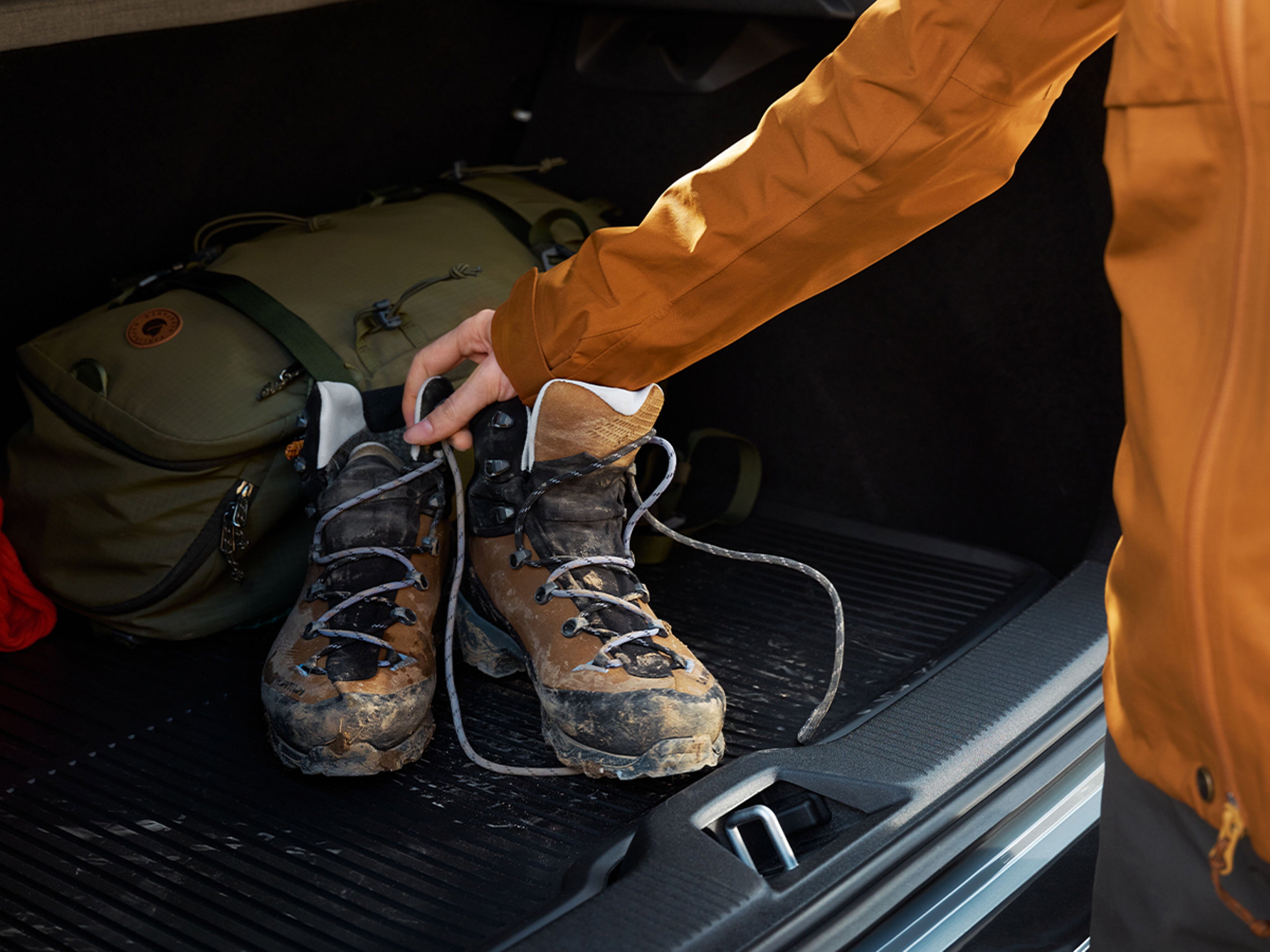 Smutsiga kängor som läggs in i ett bagageutrymme