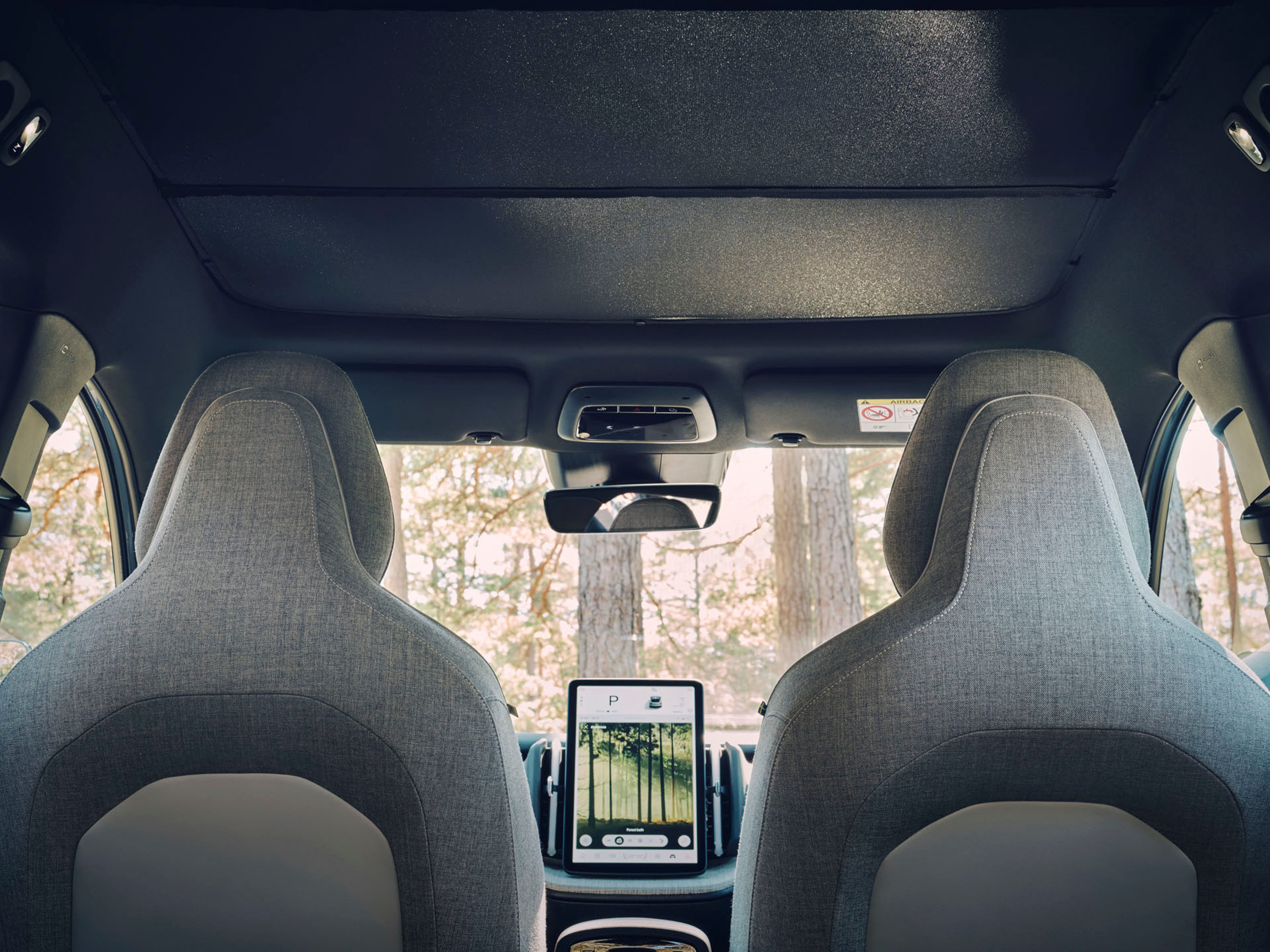 Vista desde los asientos traseros del salpicadero frontal del vehículo en el que destaca la consola central vertical.